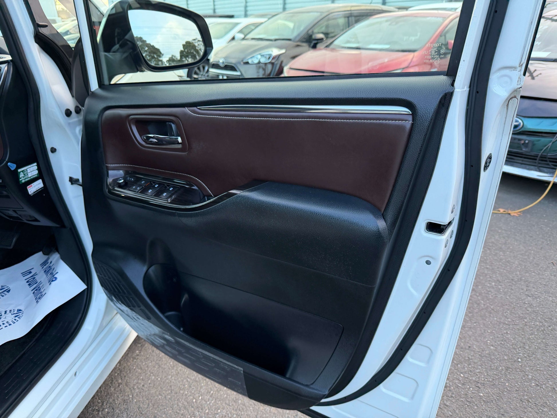 2018 Toyota Esquire 1.8L Hybrid Interior view of the driver's side door panel featuring a brown and black color scheme in a vehicle.