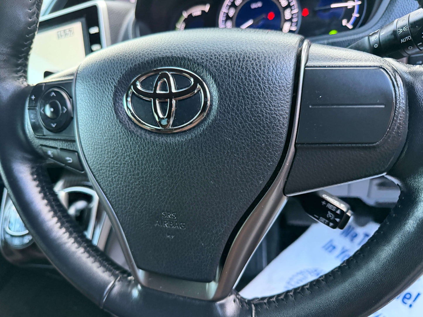 Close-up of the steering wheel with the Toyota logo in a 2018 Toyota Esquire 1.8L Hybrid interior.