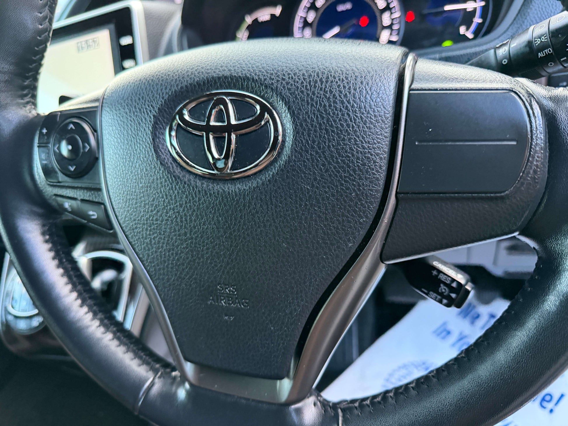 Close-up of the steering wheel with the Toyota logo in a 2018 Toyota Esquire 1.8L Hybrid interior.