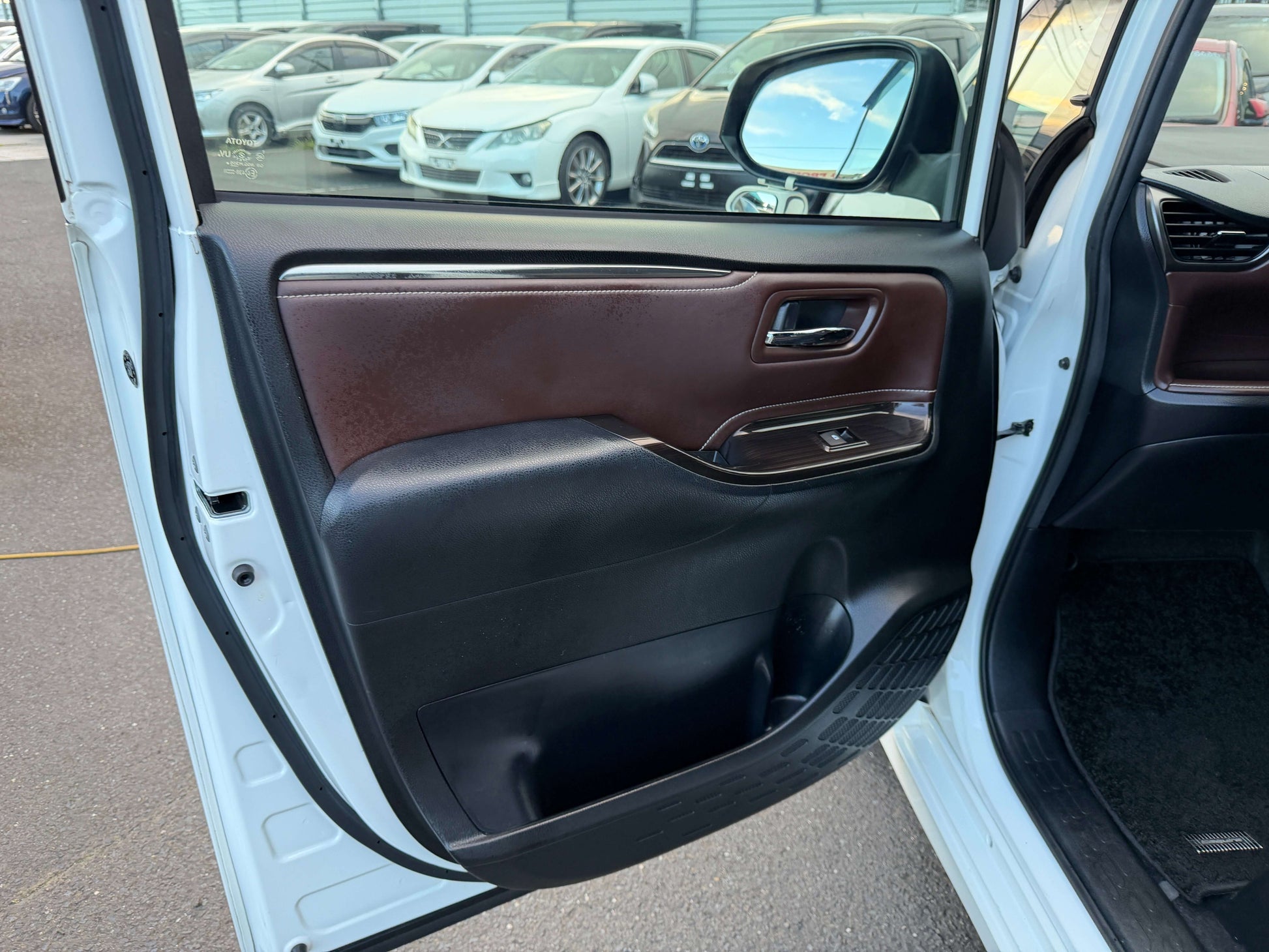 Interior view of the door panel of a 2018 Toyota Esquire 1.8L Hybrid Gi Premium Package, showcasing elegant design and premium materials.