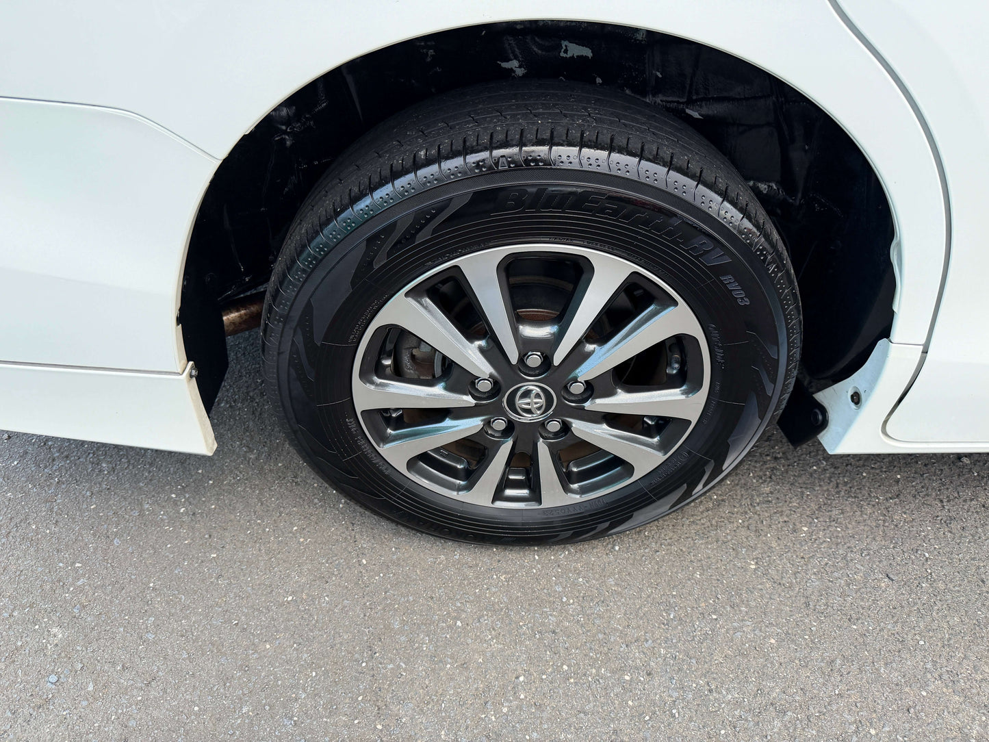 Close-up of the wheel of a 2018 Toyota Esquire 1.8L Hybrid, showcasing stylish alloy rims and tire.