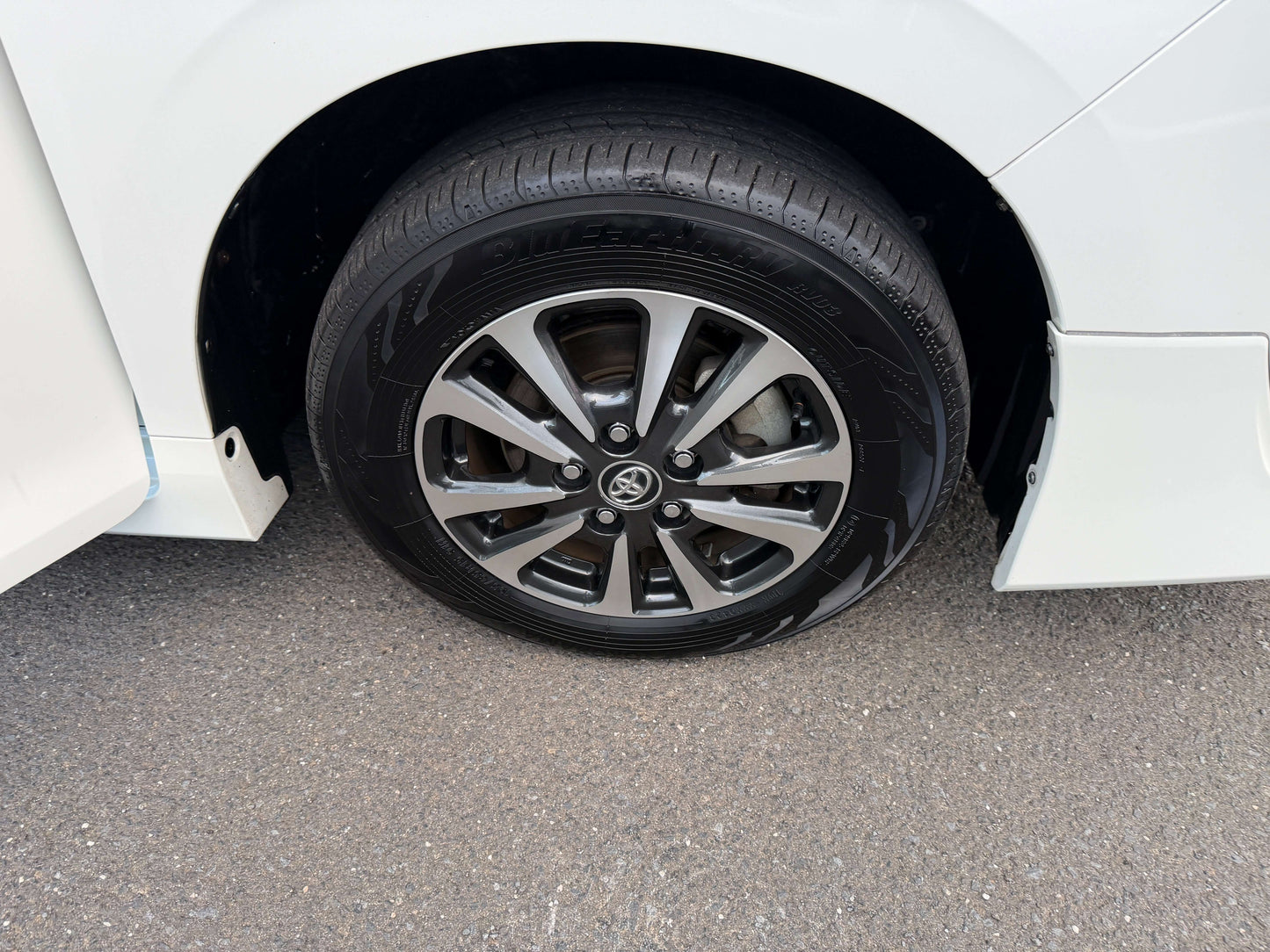 Close-up of the tire and alloy wheel of a 2018 Toyota Esquire 1.8L Hybrid, showcasing its premium design and black detailing.