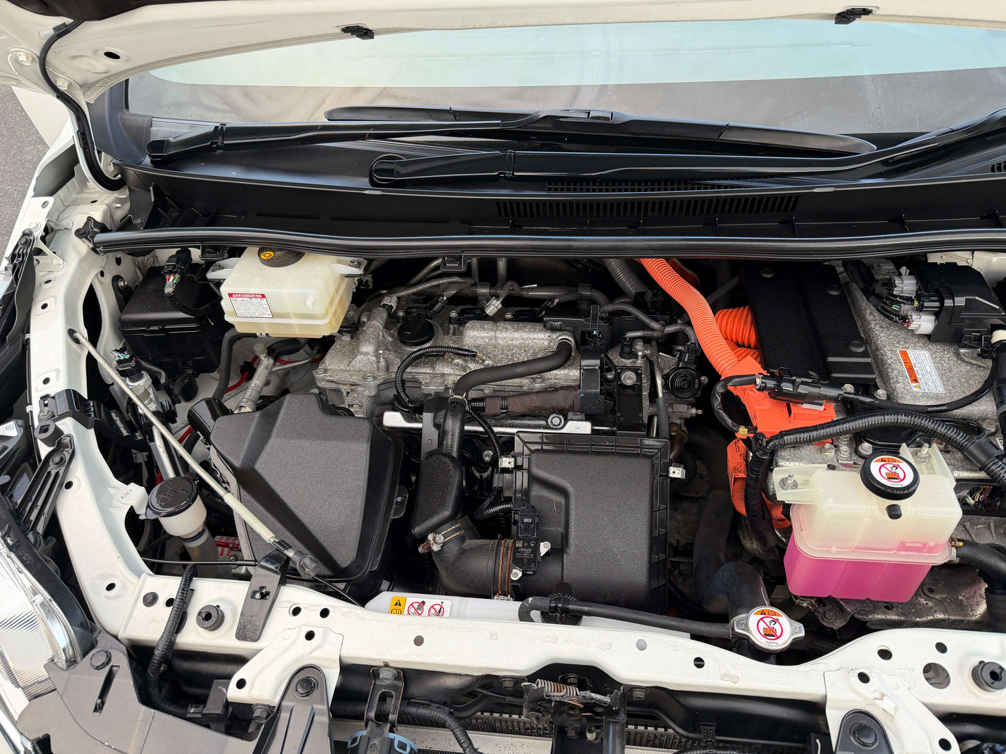 Engine compartment of 2018 Toyota Esquire 1.8L Hybrid, showcasing hybrid components and layout.