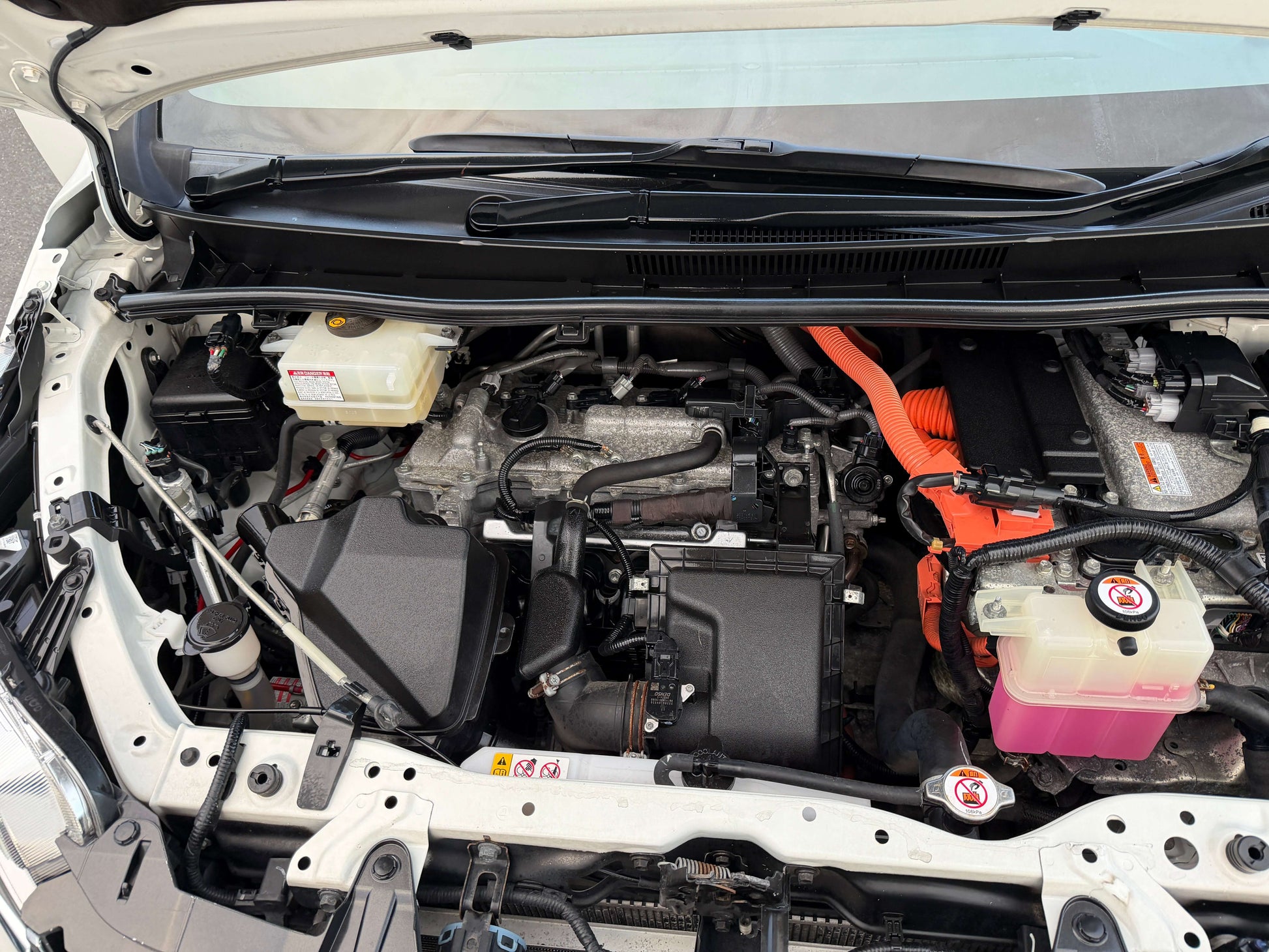 Engine compartment of 2018 Toyota Esquire 1.8L Hybrid, showcasing hybrid components and layout.