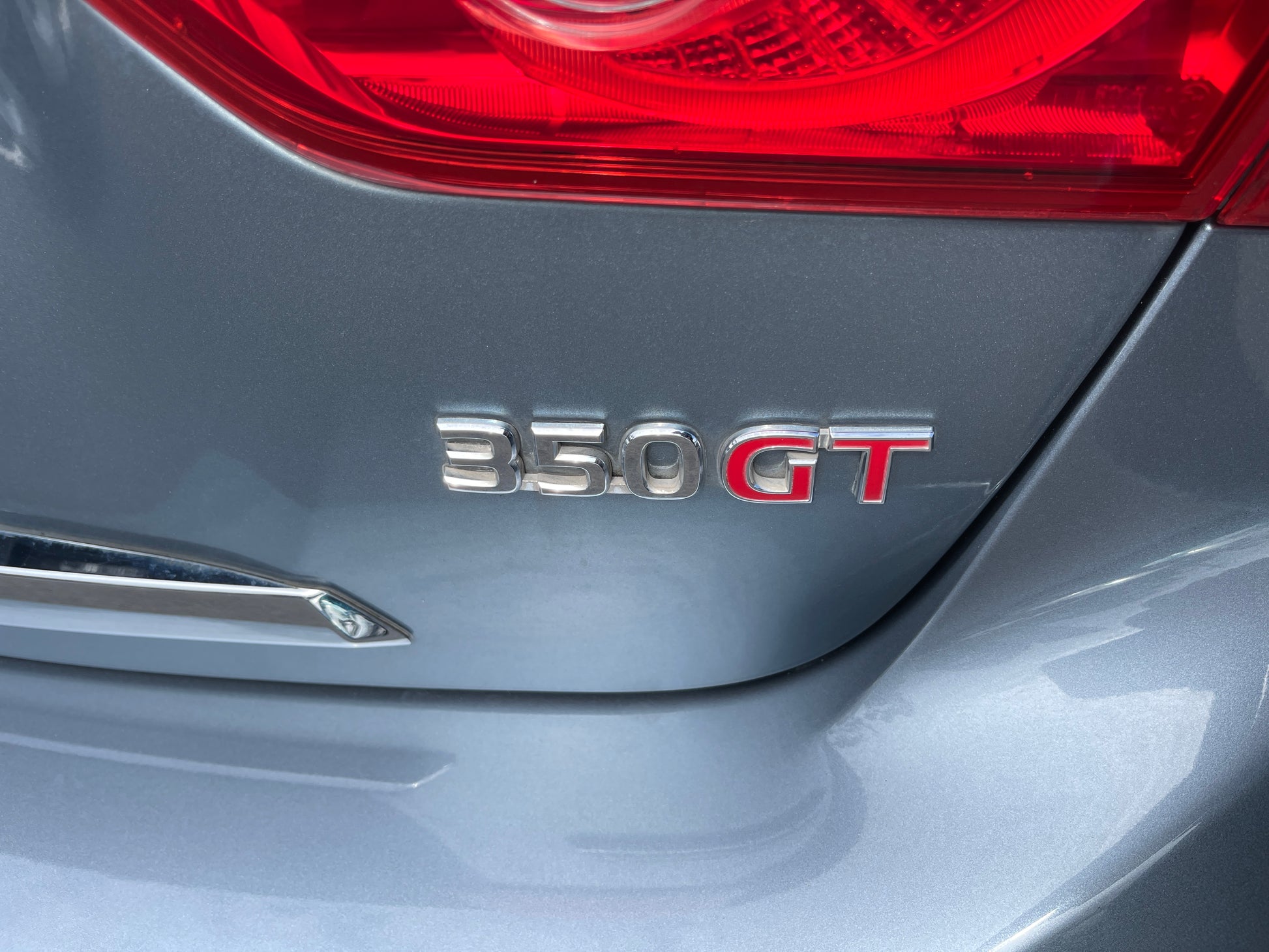 2016 Nissan Skyline V6 3.5L Hybrid 350GT badge on sport sedan rear, showcasing 350GT emblem and design details.