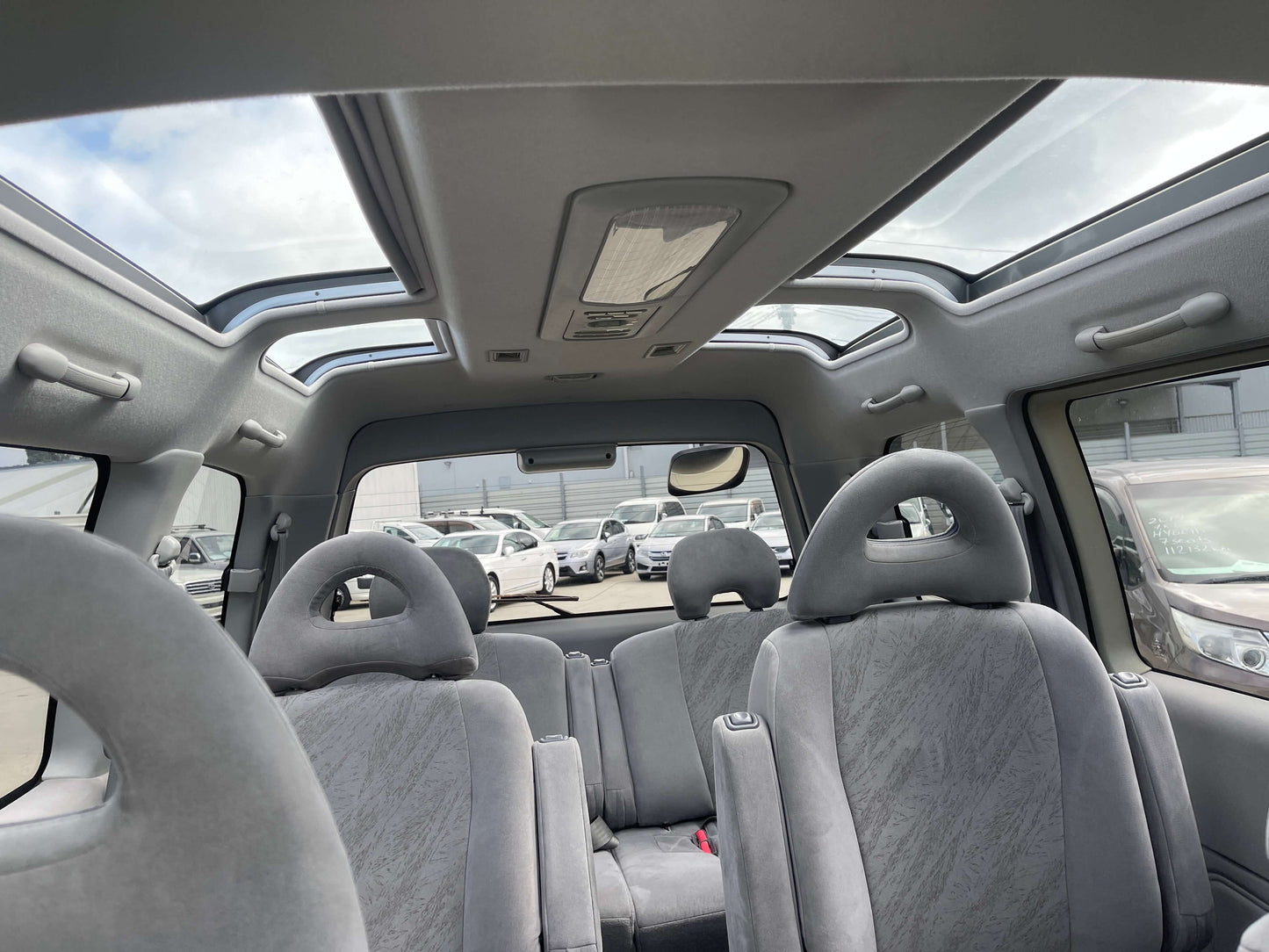 Interior view of 2006 Mitsubishi Delica Space Gear showcasing Skylite roof and gray upholstery.