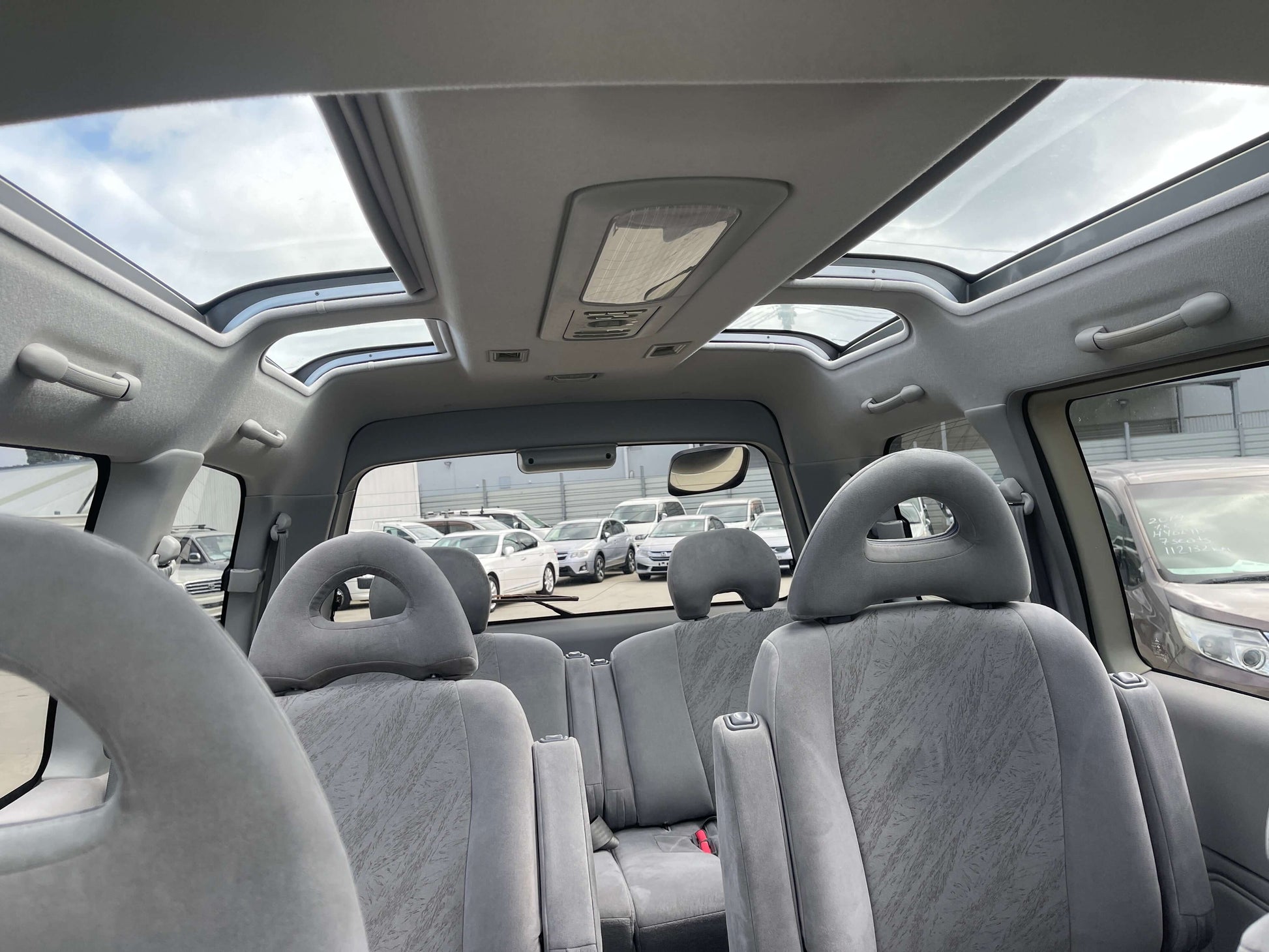 Interior view of 2006 Mitsubishi Delica Space Gear showcasing Skylite roof and gray upholstery.