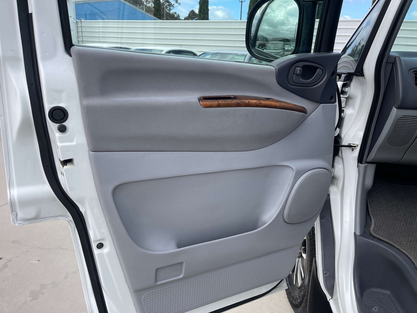 2006 Mitsubishi Delica door interior with wood accents and grey panel.