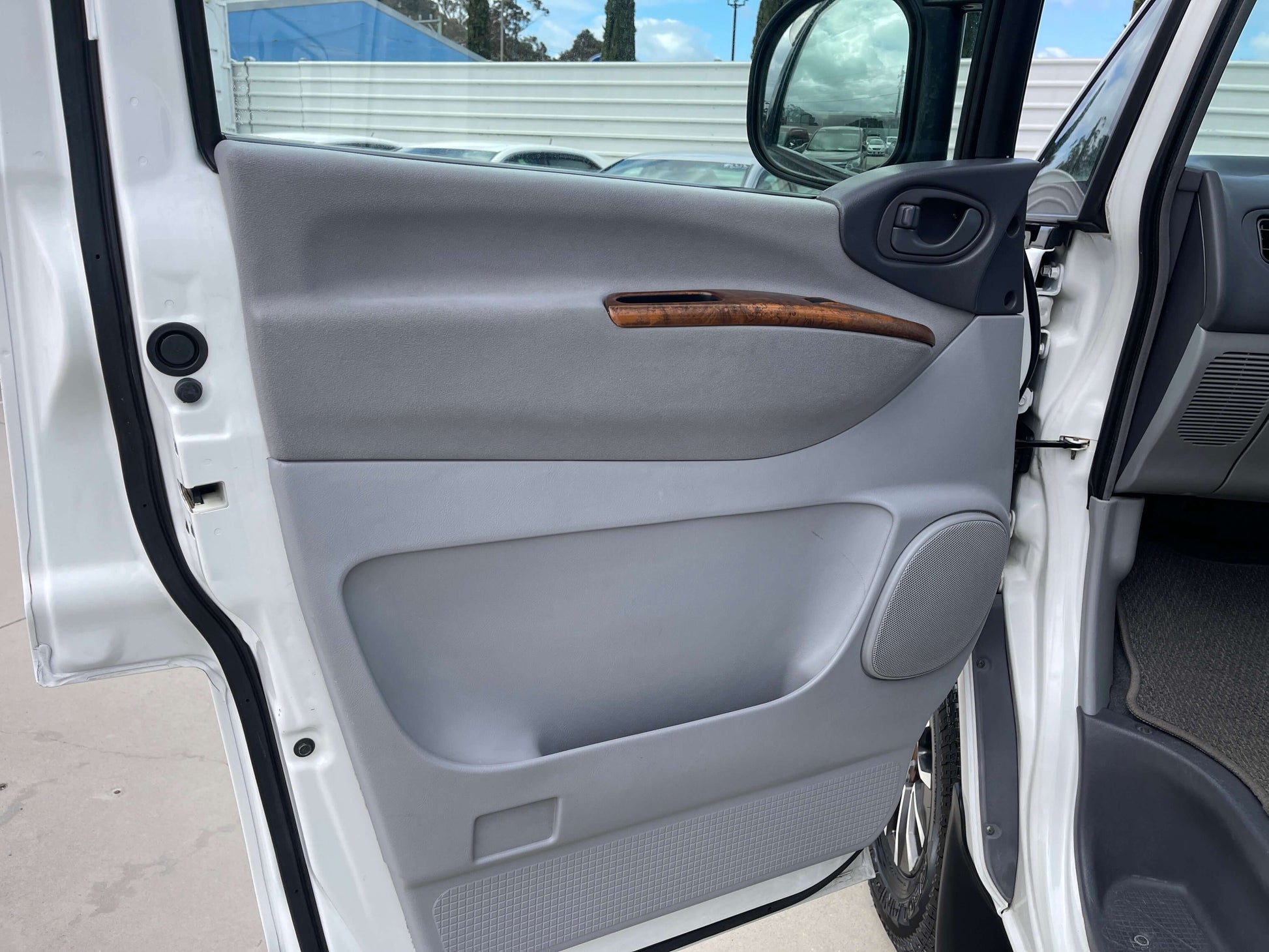 2006 Mitsubishi Delica door interior with wood accents and grey panel.