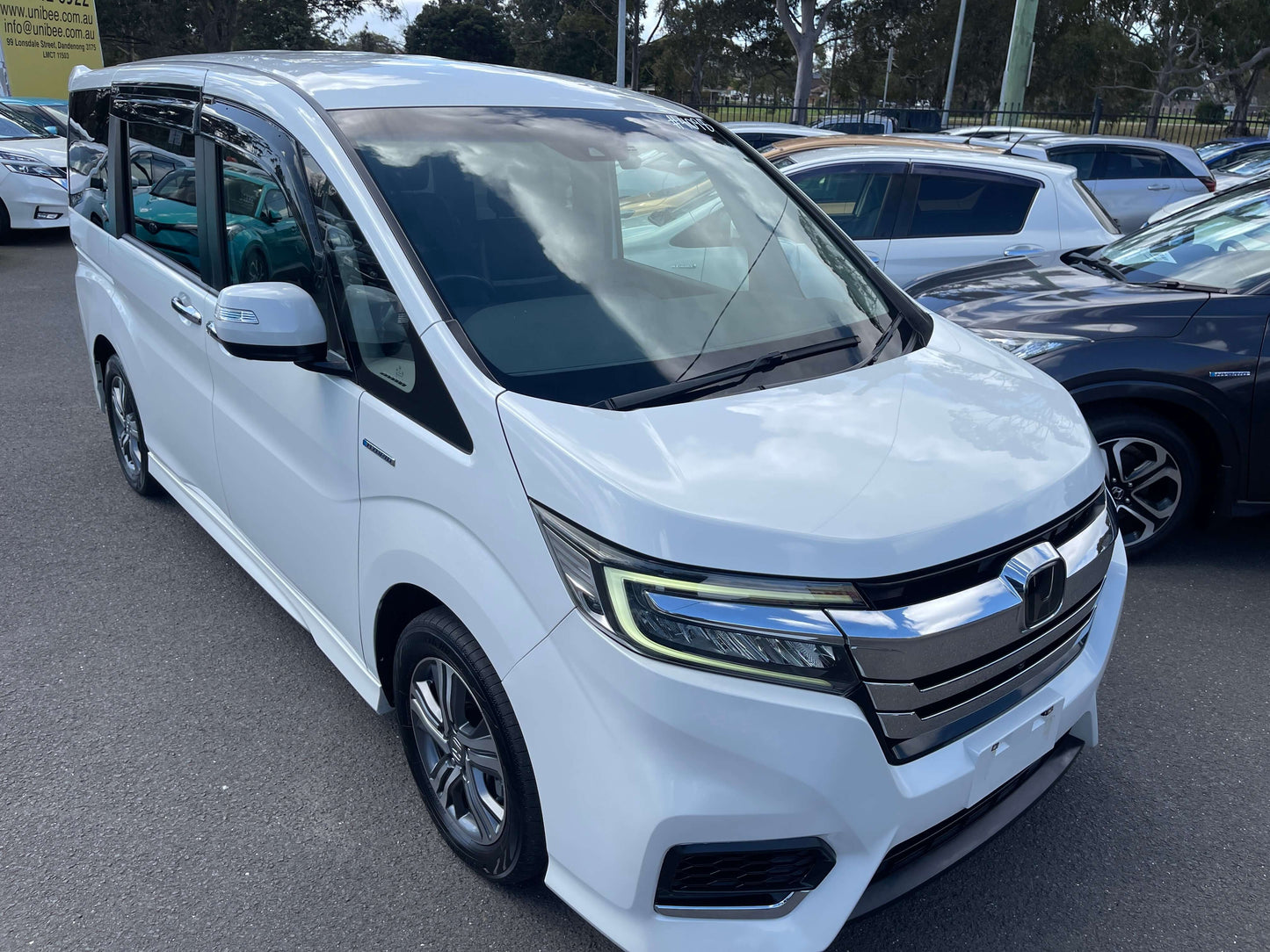 2018 Honda Stepwgn 2.0 Spada Hybrid G Honda Sensing parked in a car lot, showcasing its sleek white exterior.