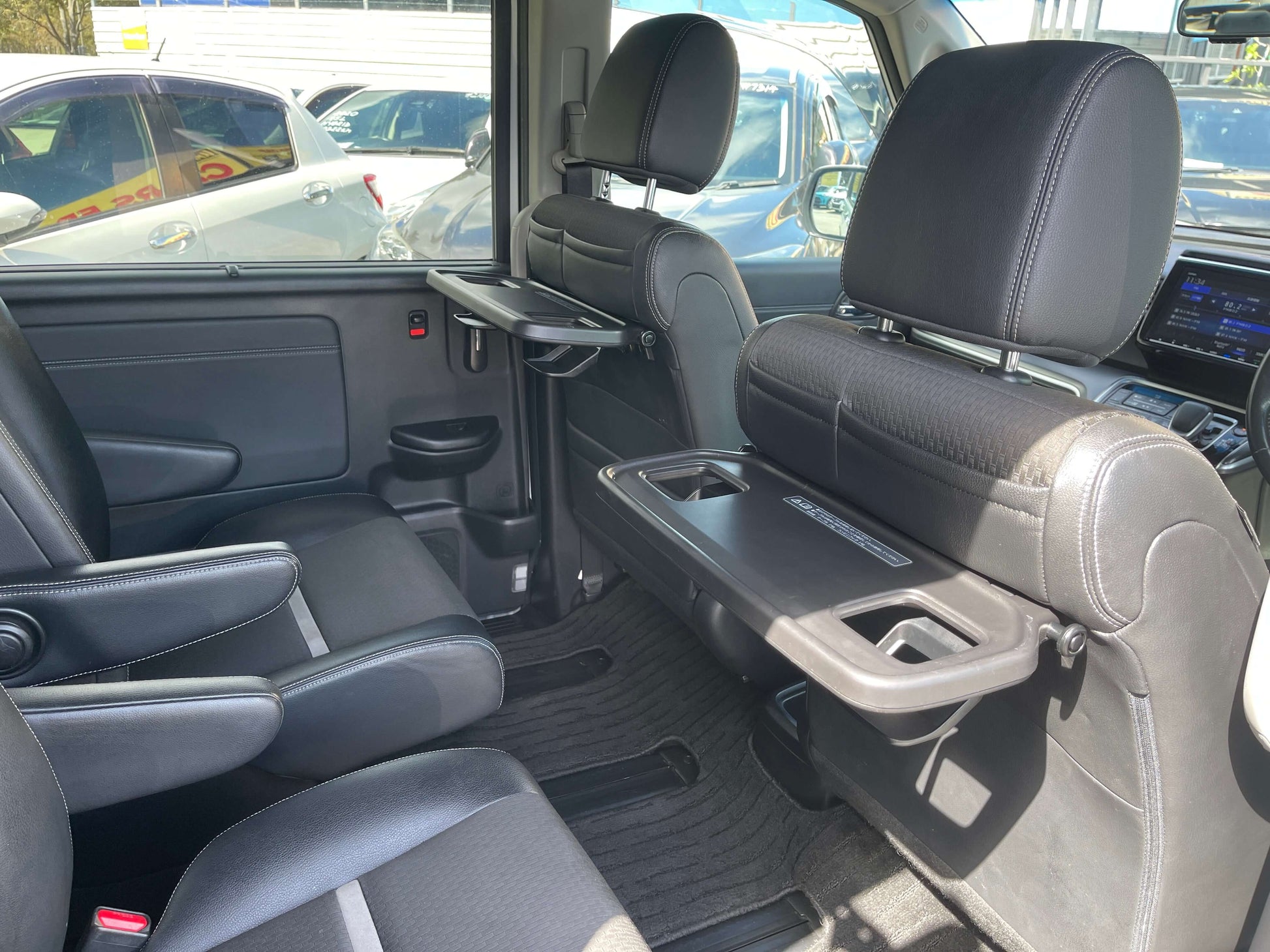 Interior view of the 2018 Honda Stepwgn 2.0 Spada Hybrid featuring spacious seating and foldable tables.