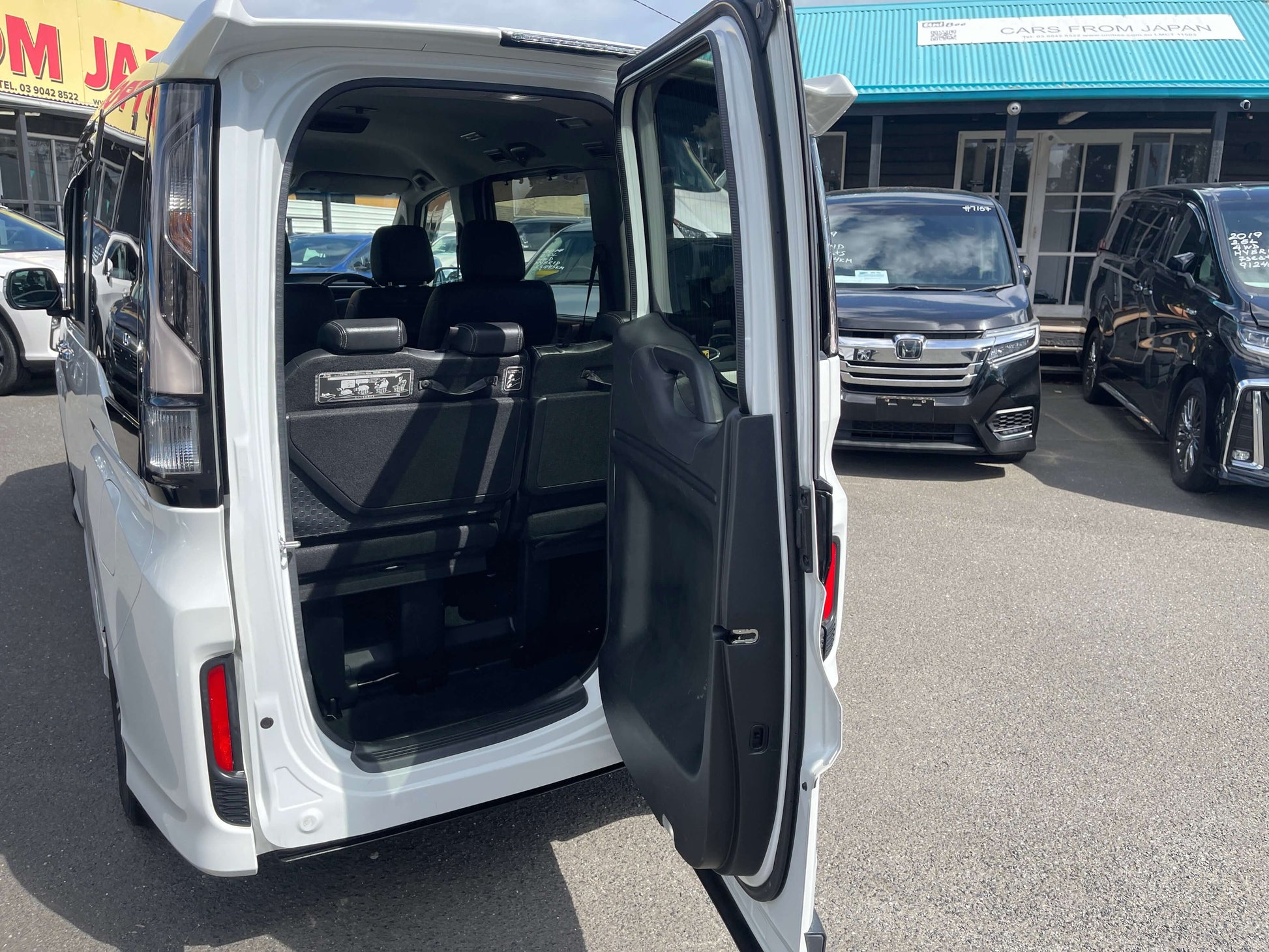 Interior view of the 2018 Honda Stepwgn 2.0 Spada Hybrid G Honda Sensing with open side door, showcasing seating.