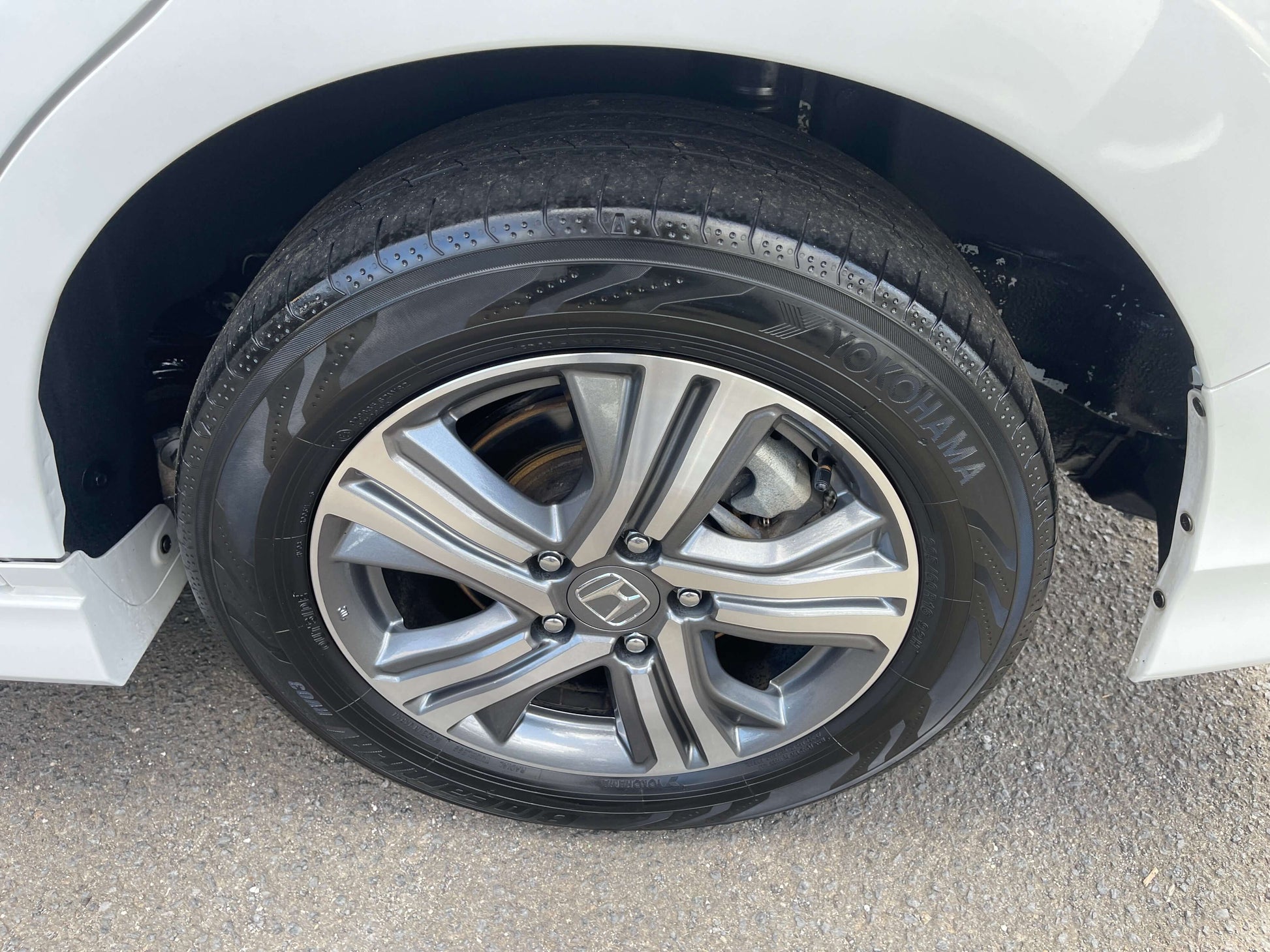 Close-up of the wheel and tire of a 2018 Honda Stepwgn 2.0 Spada Hybrid, showcasing stylish alloy rims.