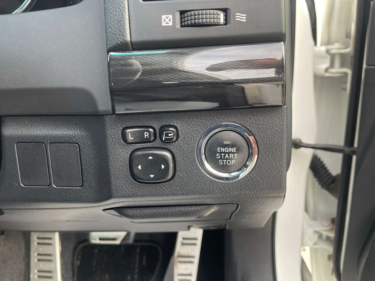 Interior control panel of 2011 Toyota Mark X showing engine start stop button and adjustment controls.