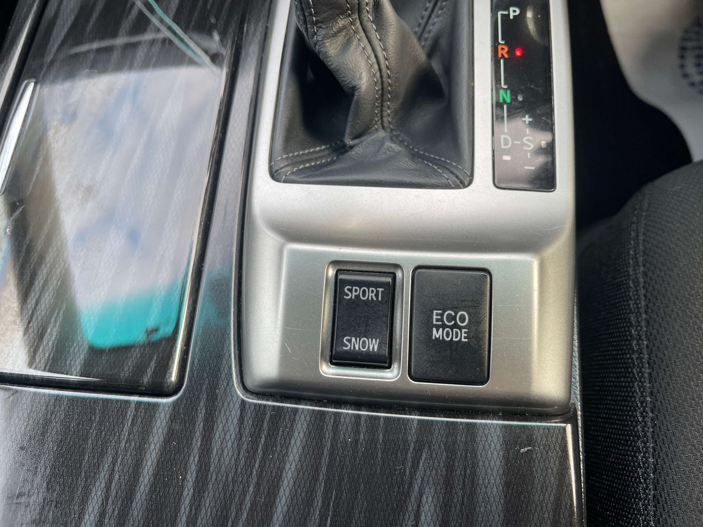 Interior controls of a 2011 Toyota Mark X, featuring buttons for Sport, Snow, and Eco Mode driving options.