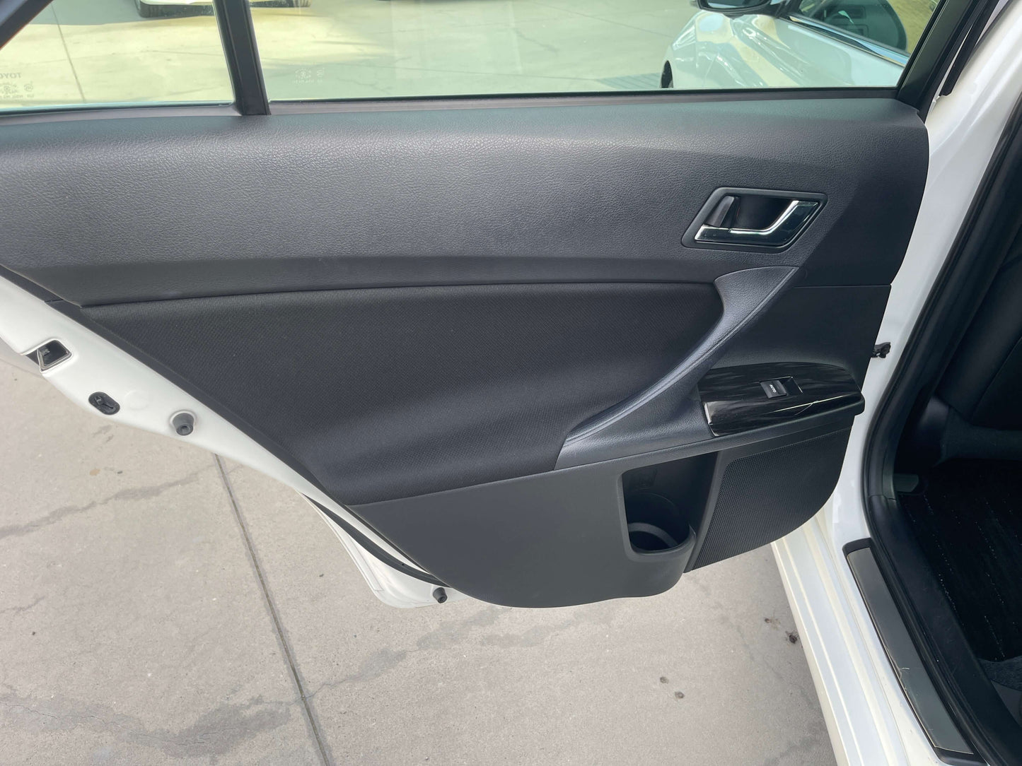 Interior view of the driver's side door of a 2011 Toyota Mark X with black panel and controls.
