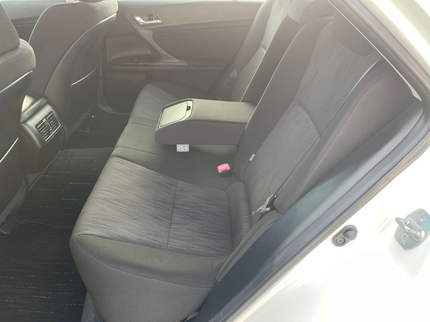 Interior view of the back seat of a 2011 Toyota Mark X V6 3.5L 350S Sport Sedan showcasing luxury seating.
