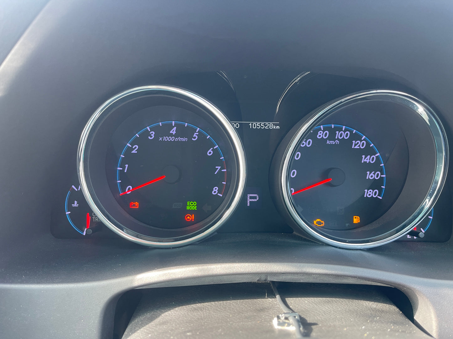 Dashboard of 2011 Toyota Mark X showing speedometer, tachometer, and warning lights with 105,528 km on odometer.