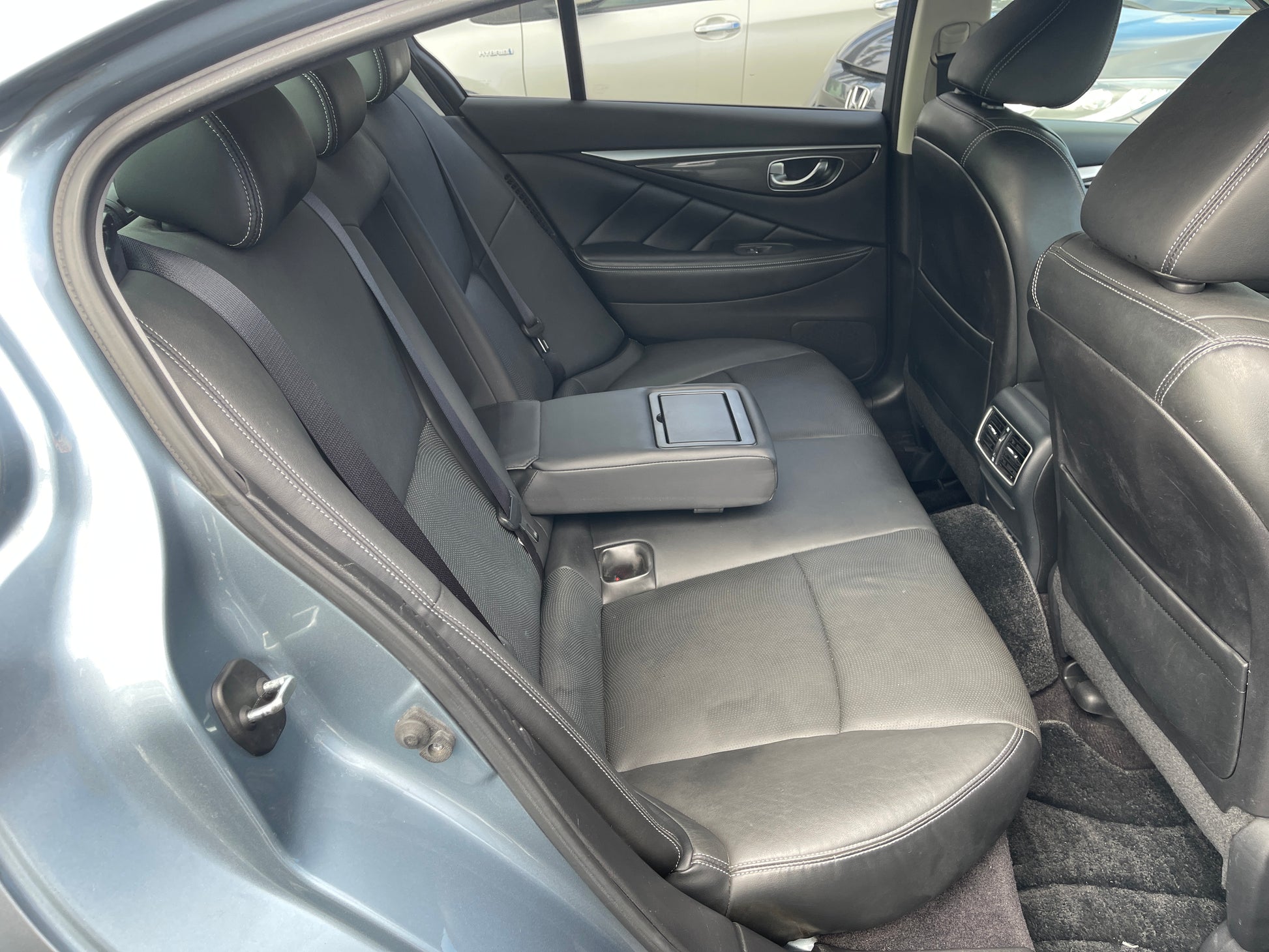 Interior view of the back seat of a 2016 Nissan Skyline V6 3.5L Hybrid 350GT, featuring black leather upholstery.