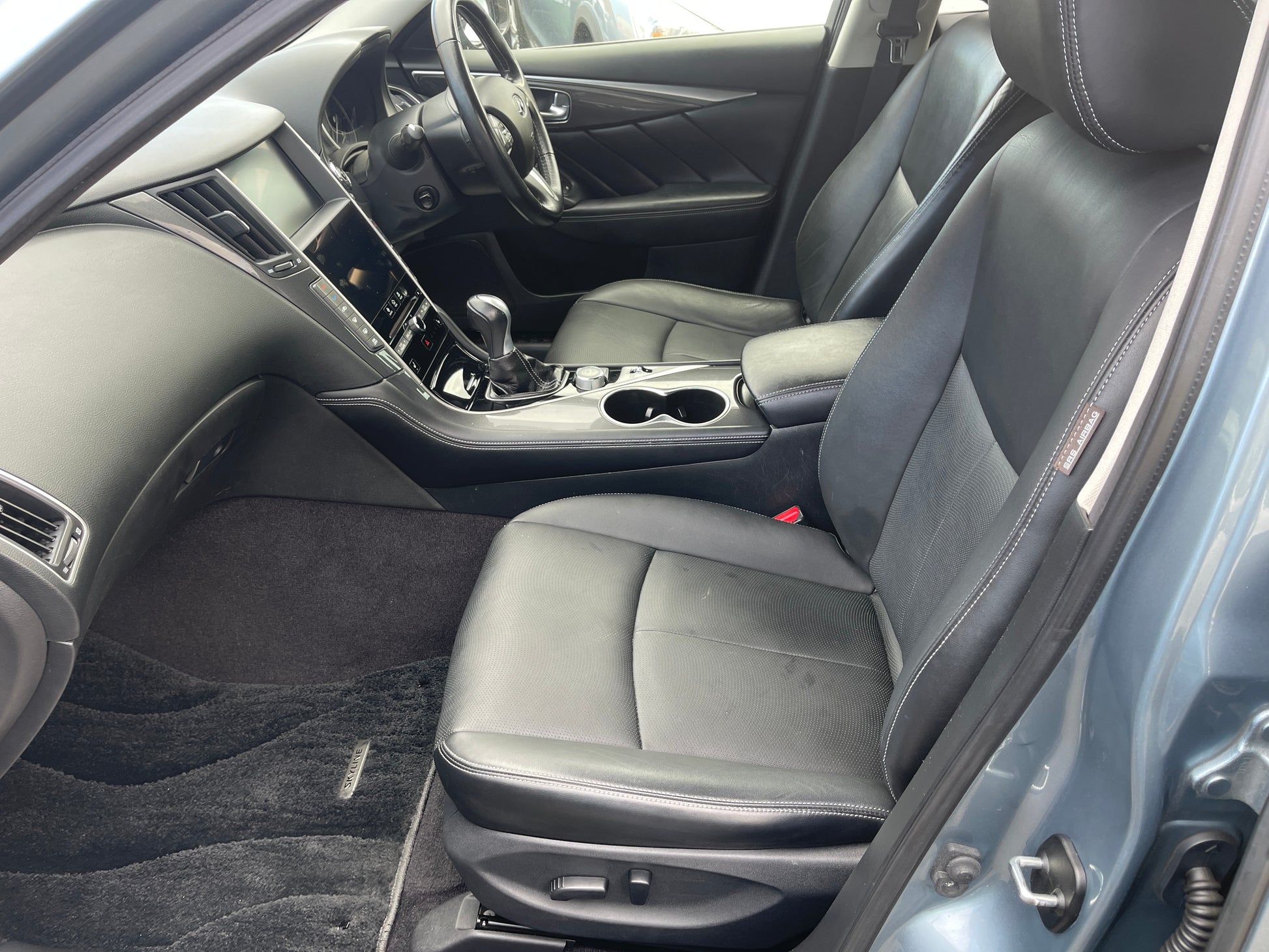 Interior of a 2016 Nissan Skyline V6 3.5L Hybrid with black leather seats and modern dashboard features.