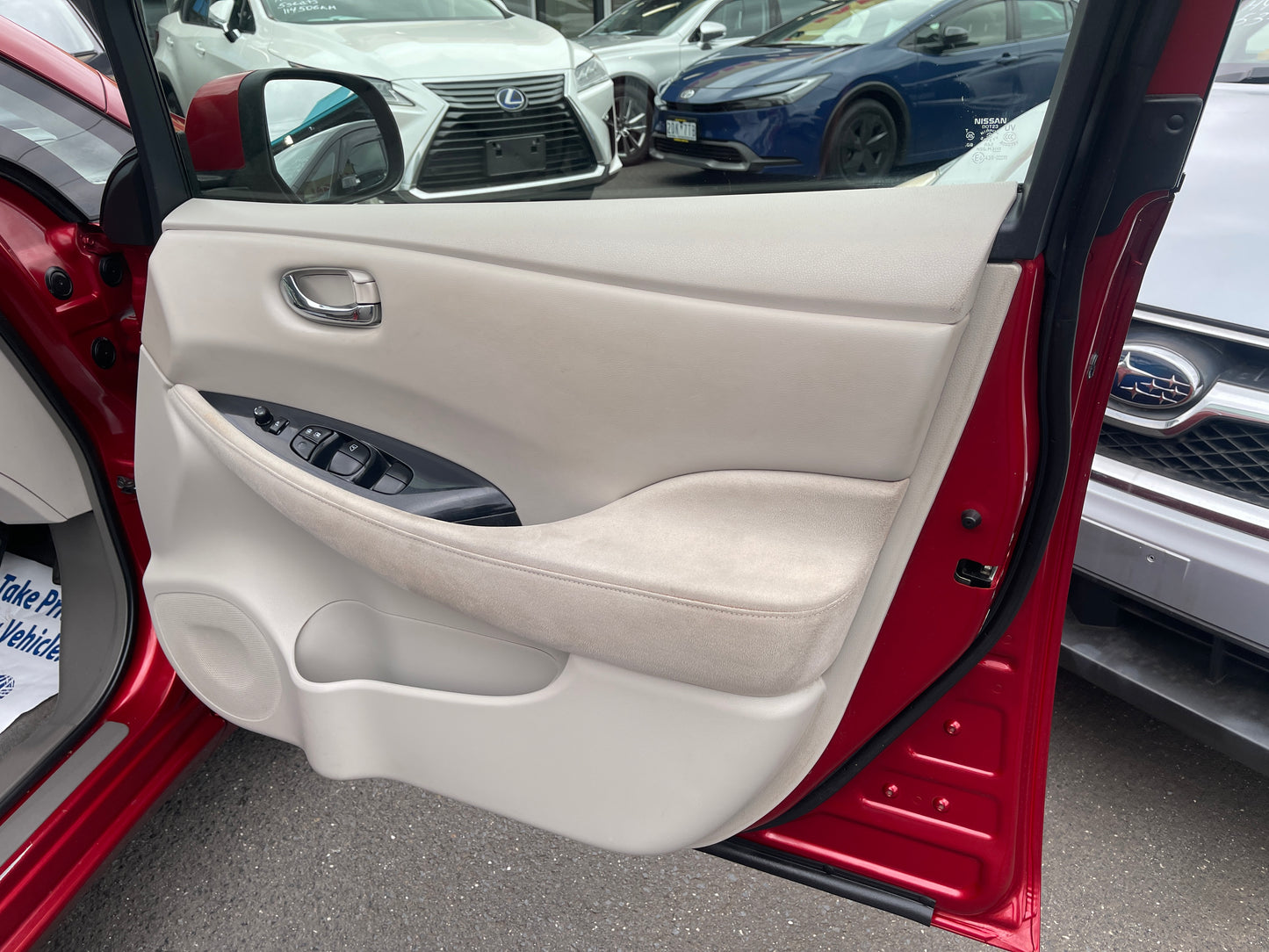 Interior door panel of 2013 Nissan Leaf 24kW G-Edition Full Electric with control buttons.