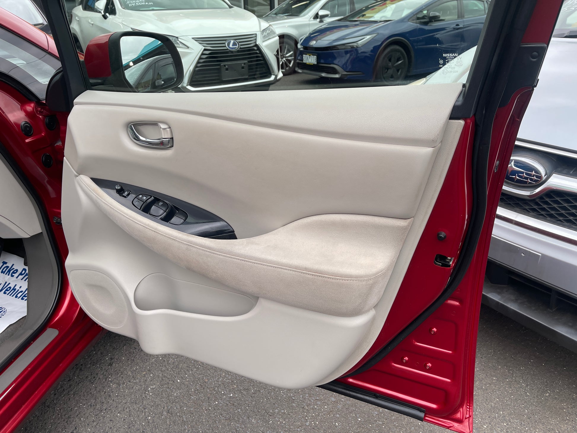Interior door panel of 2013 Nissan Leaf 24kW G-Edition Full Electric with control buttons.