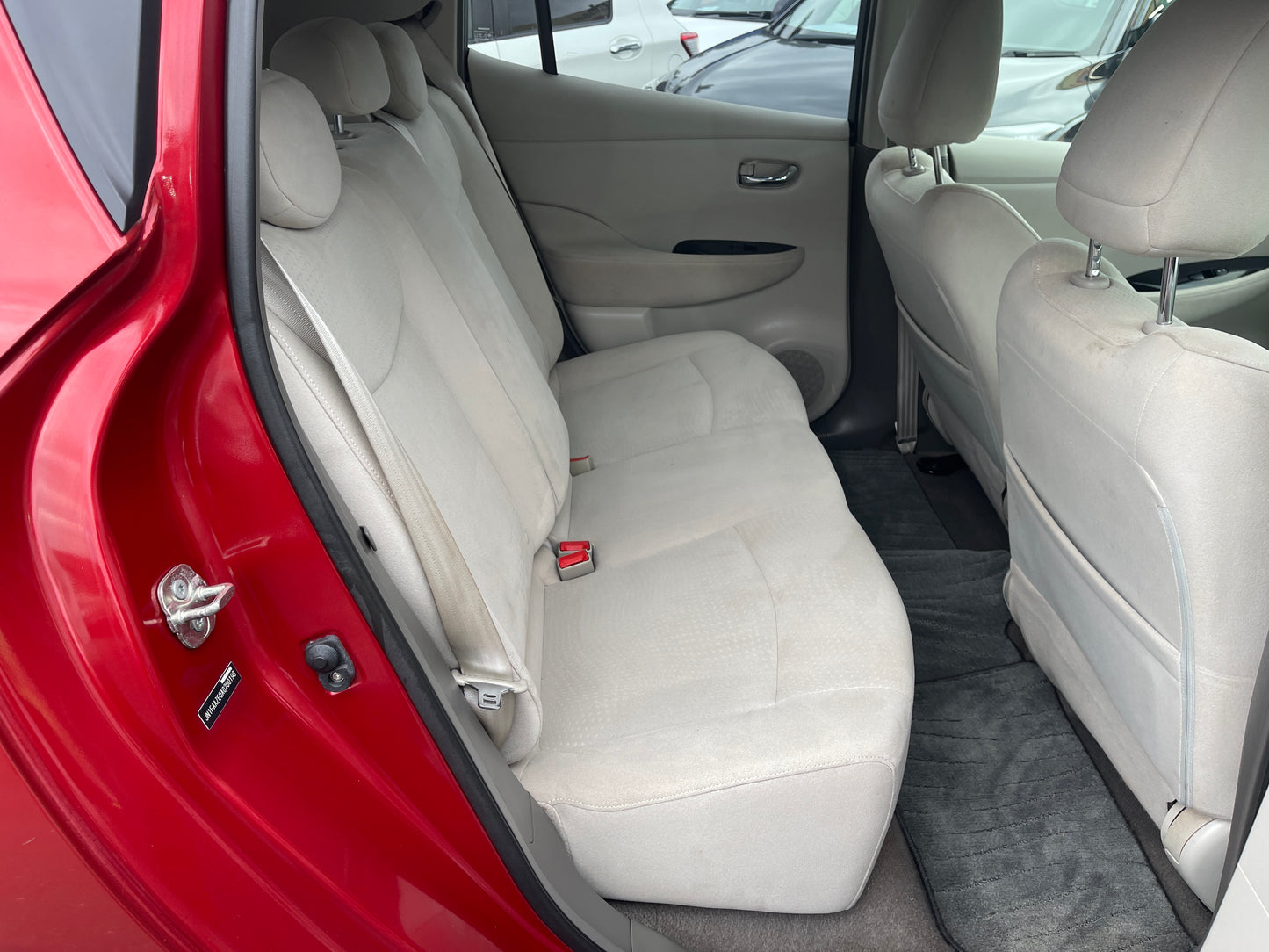 2013 Nissan Leaf 24kW G-Edition Full Electric interior back seat view, spacious and comfortable with light upholstery.