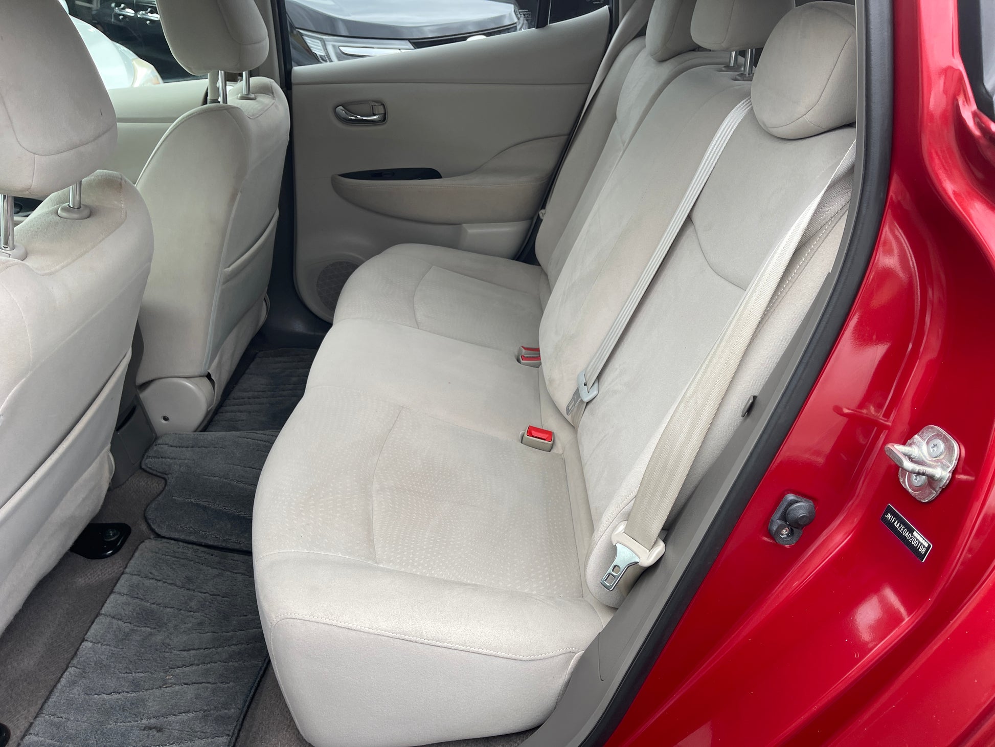 Interior view of the back seats in a 2013 Nissan Leaf 24kW G-Edition Full Electric, featuring light upholstery.