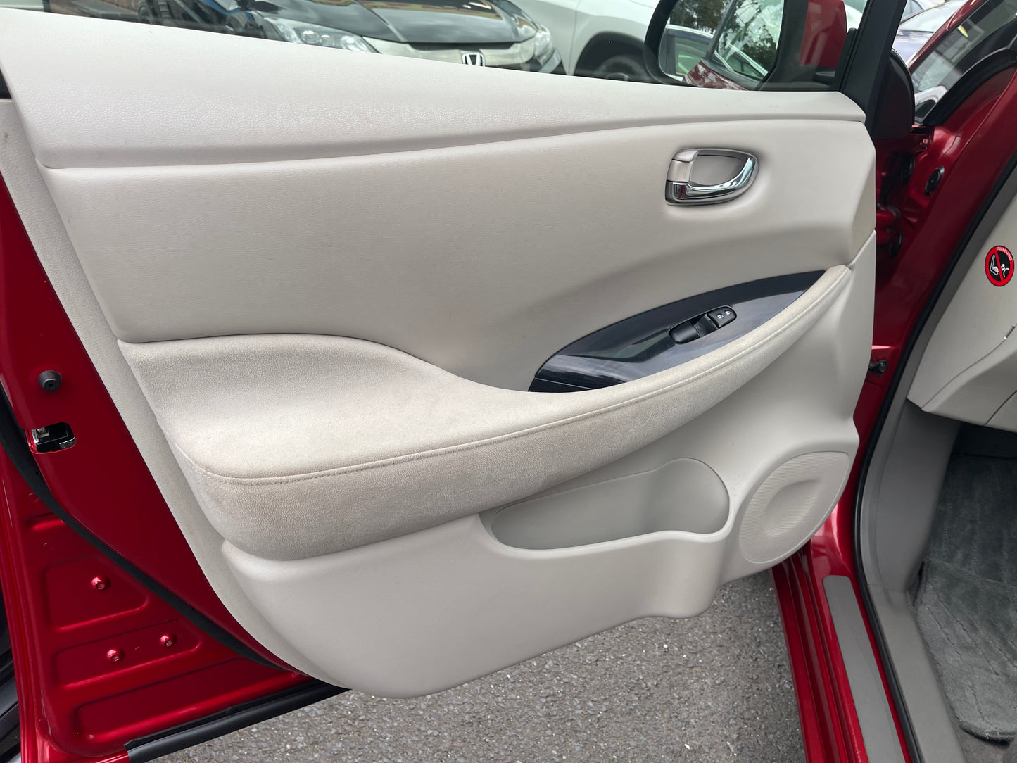 Interior door panel of a 2013 Nissan Leaf 24kW G-Edition Full Electric, showcasing features and design.