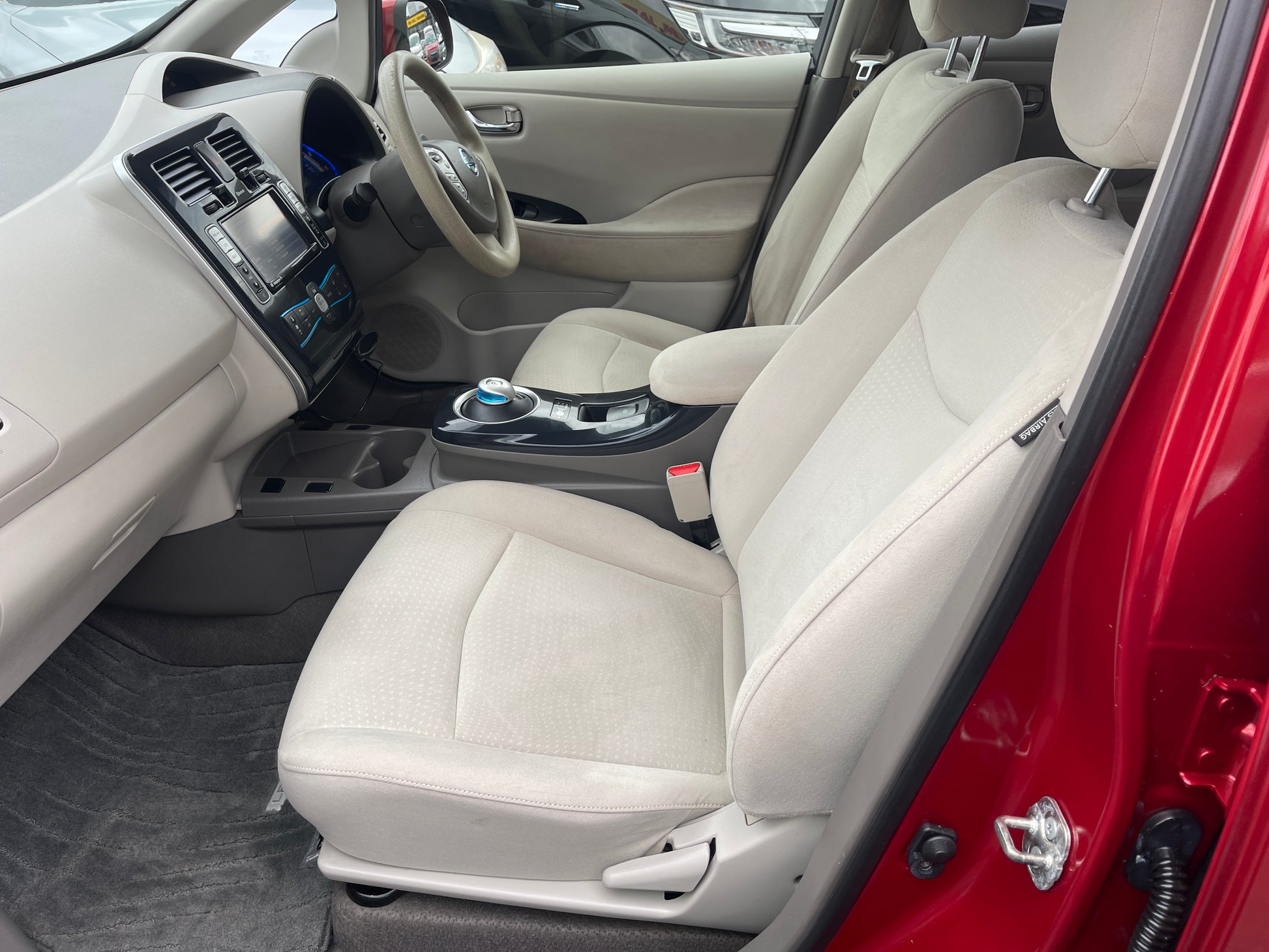Interior view of a 2013 Nissan Leaf 24kW G-Edition Full Electric with spacious gray seats and modern dashboard.