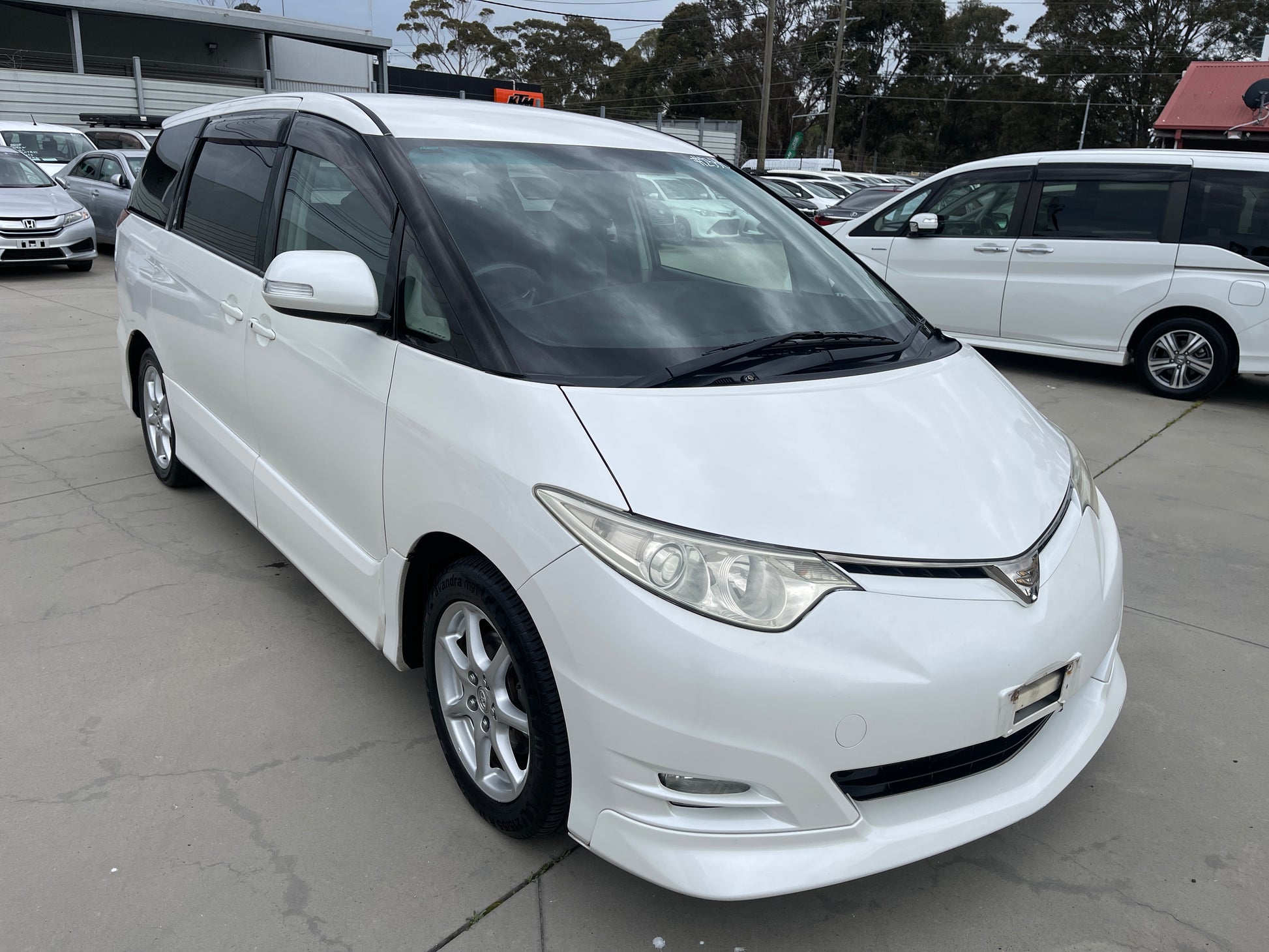 2006 Toyota Estima Aeras V6 3.5L white exterior viewed from the front, showcasing its sleek design and spacious 7 seater layout.