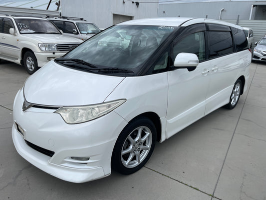 2006 Toyota Estima Aeras V6 3.5L in white color, 7 seater, parked in a lot, showcasing its sleek design and sporty wheels.