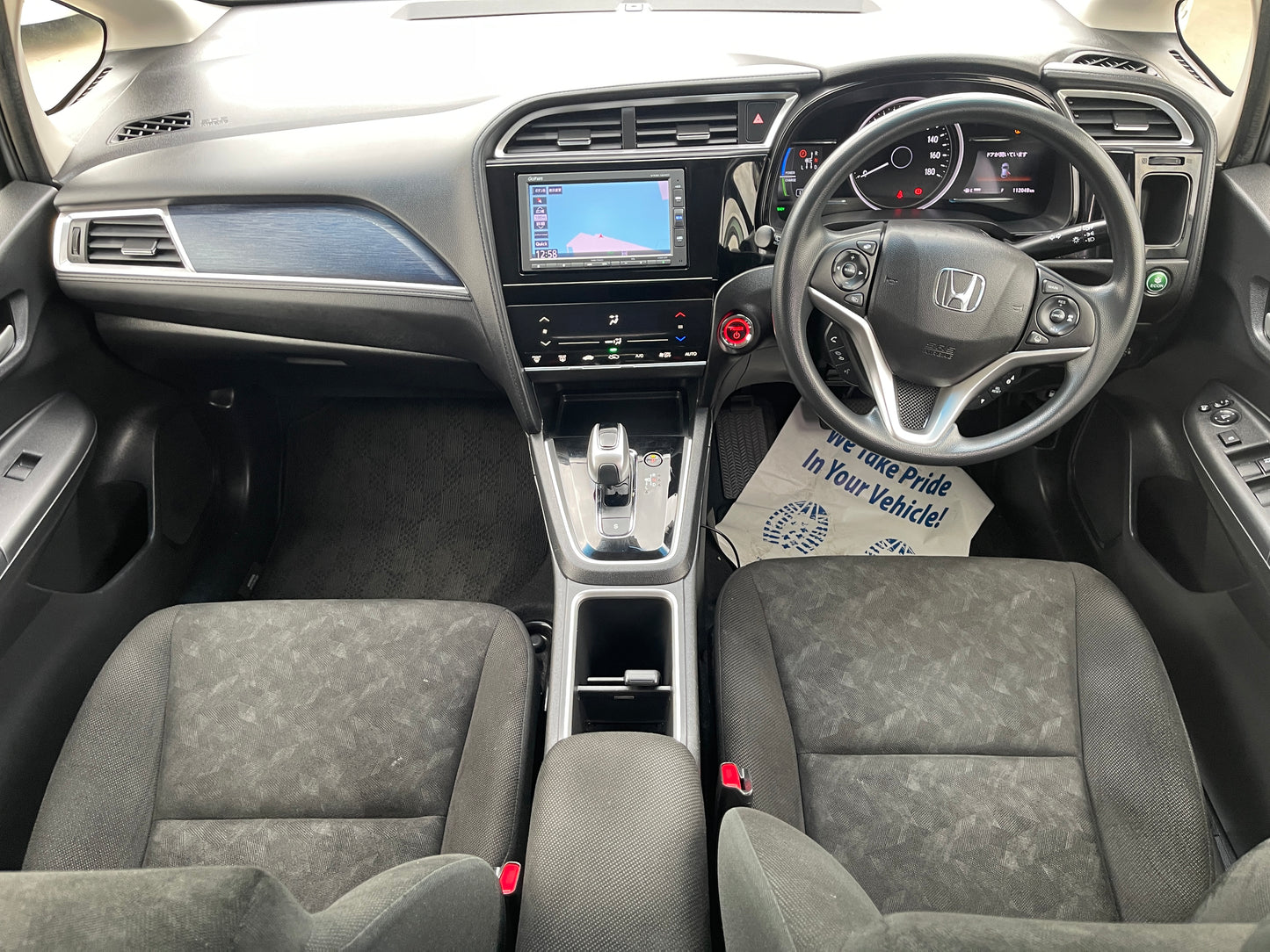 Interior view of a 2018 Honda Shuttle 1.5 Hybrid, showcasing dashboard, seats, and technology features.