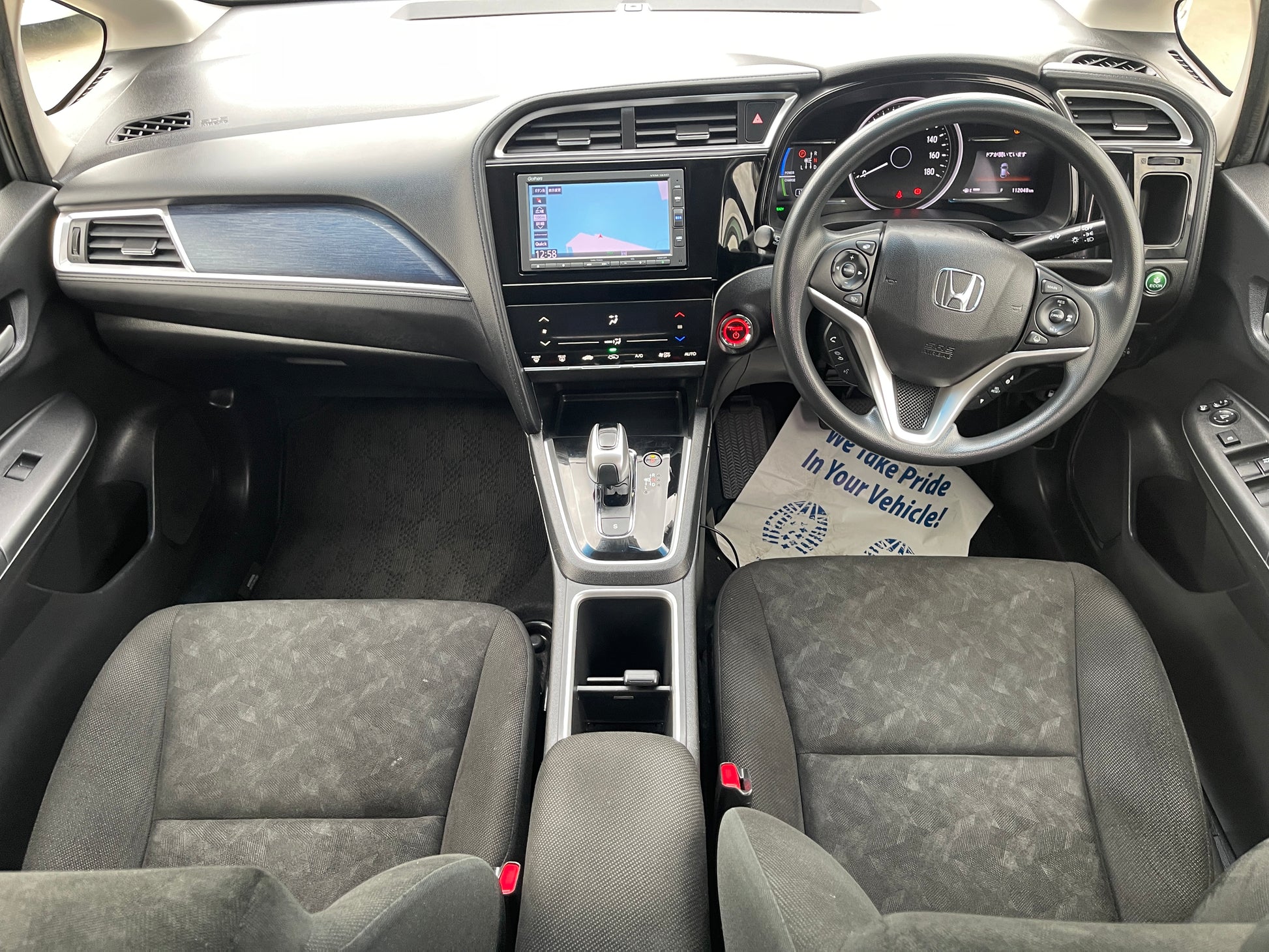 Interior view of a 2018 Honda Shuttle 1.5 Hybrid, showcasing dashboard, seats, and technology features.