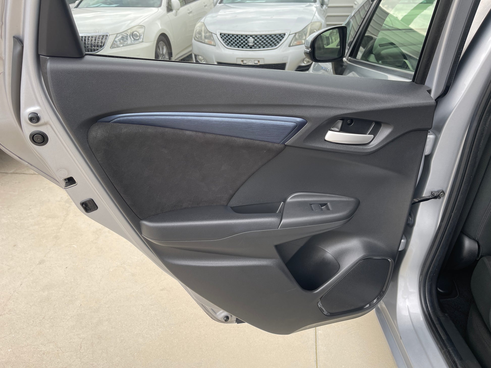 Interior door panel of 2018 Honda Shuttle 1.5 Hybrid showcasing modern design and features.