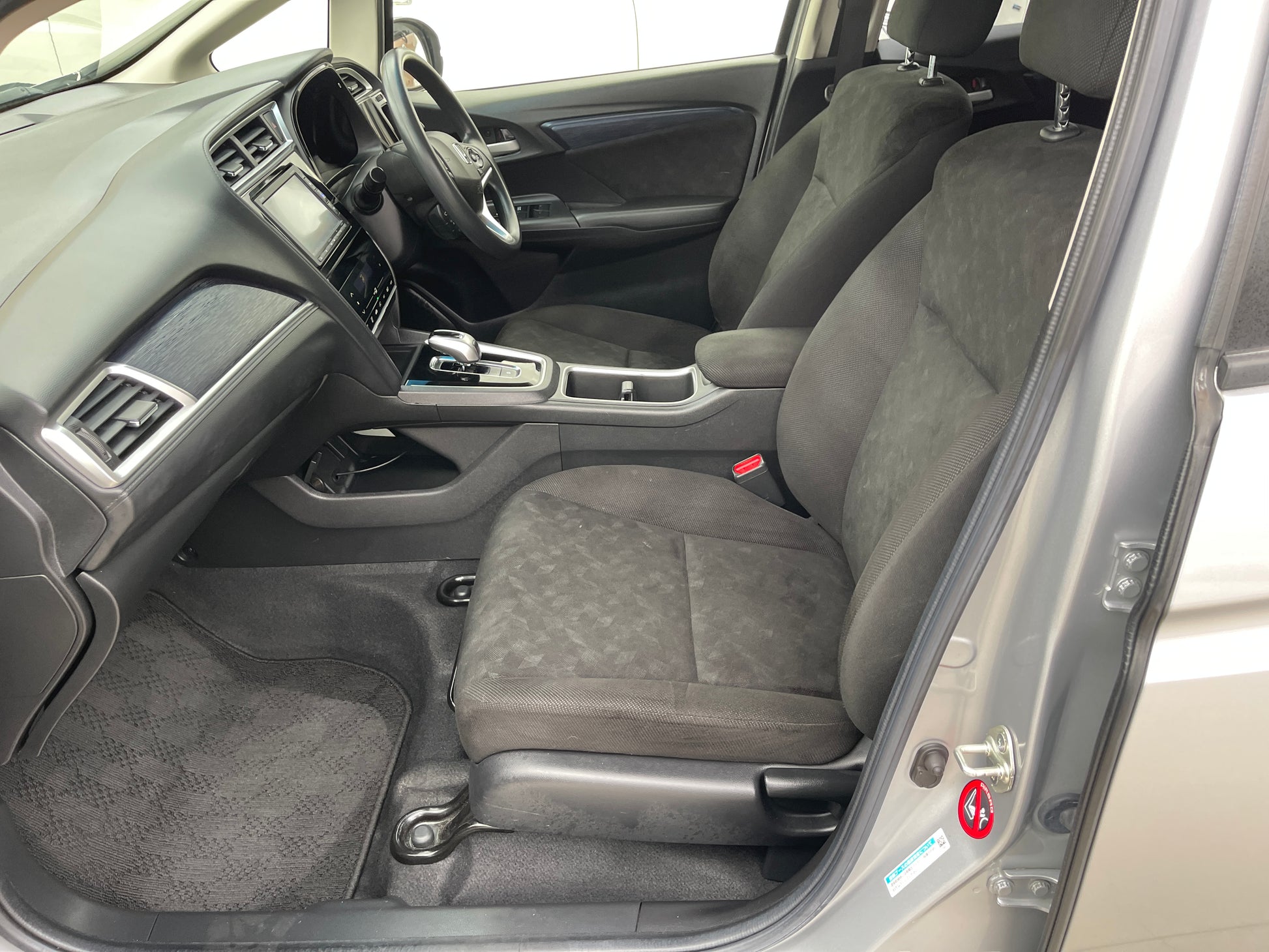 Interior view of 2018 Honda Shuttle 1.5 Hybrid X showing spacious front seating and dashboard features.
