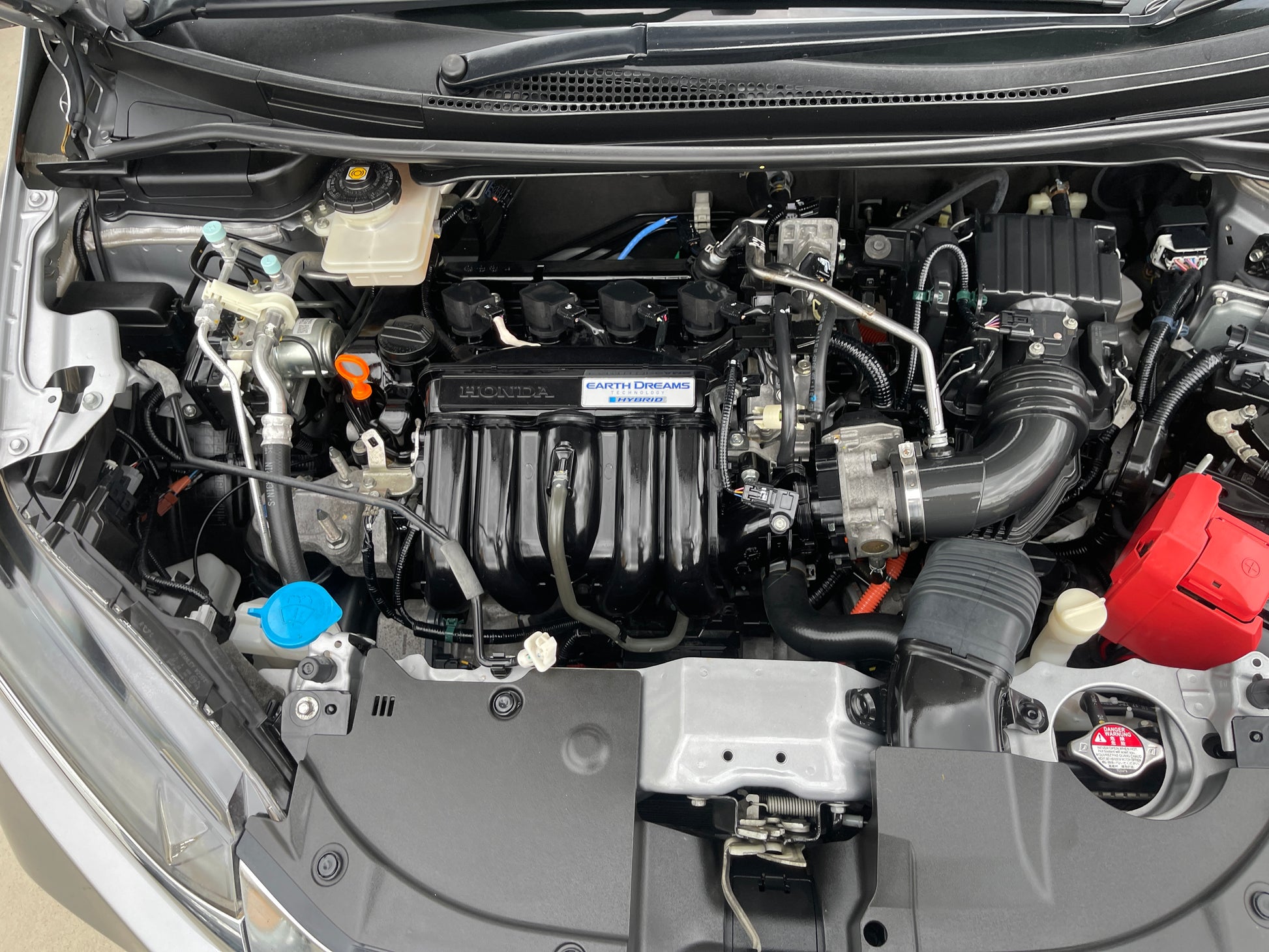 Engine compartment of a 2018 Honda Shuttle 1.5 Hybrid showcasing the hybrid system and components.
