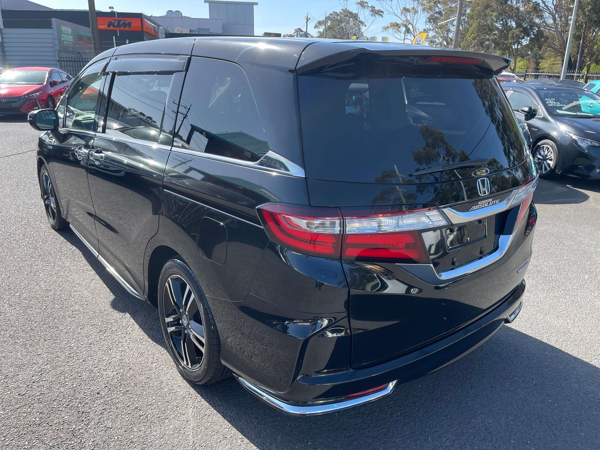 2016 Honda Odyssey 2.0 Hybrid Absolute Honda Sensing black minivan rear view with sleek design and tinted windows