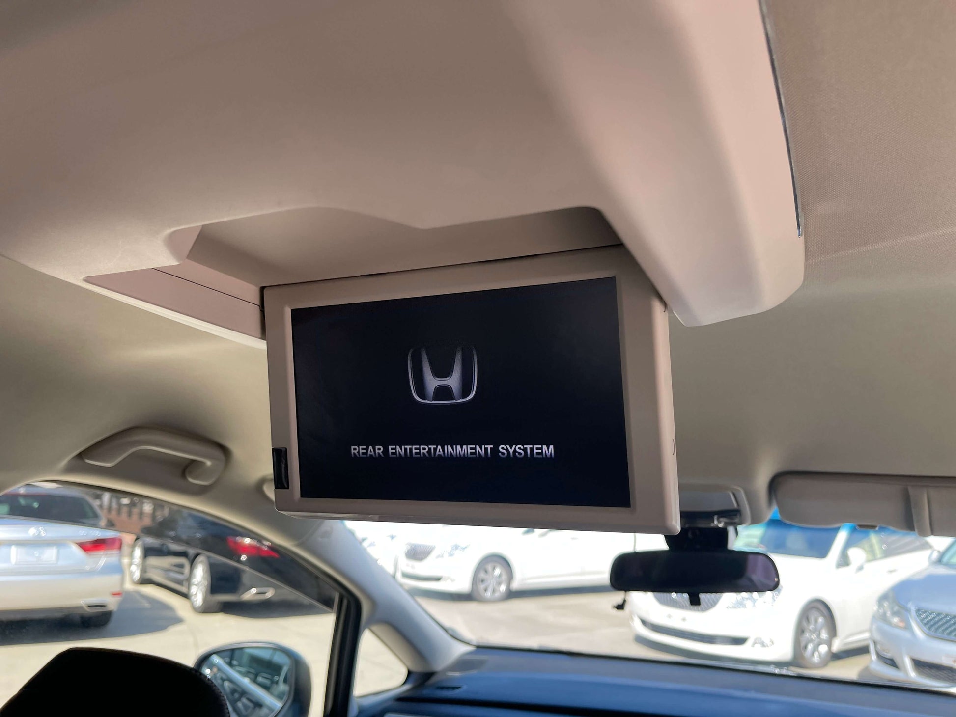 2016 Honda Odyssey 2.0 Hybrid Rear entertainment system display in a Honda vehicle, showing Honda logo and system title.