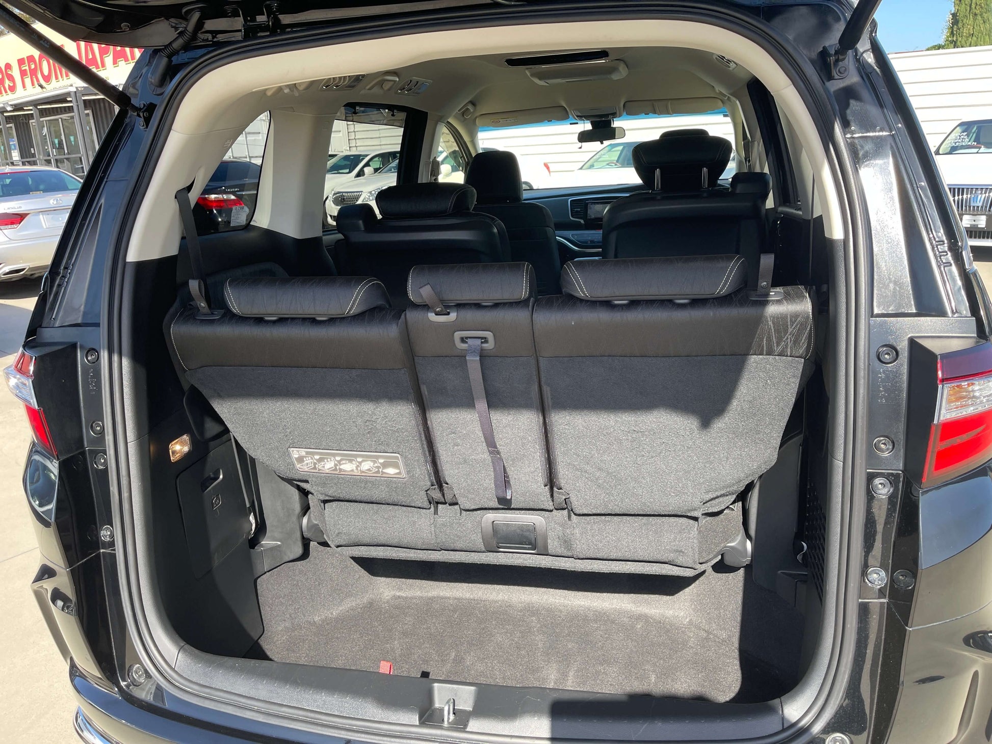 Interior view of the 2016 Honda Odyssey 2.0 Hybrid showing spacious back seats with ample legroom.