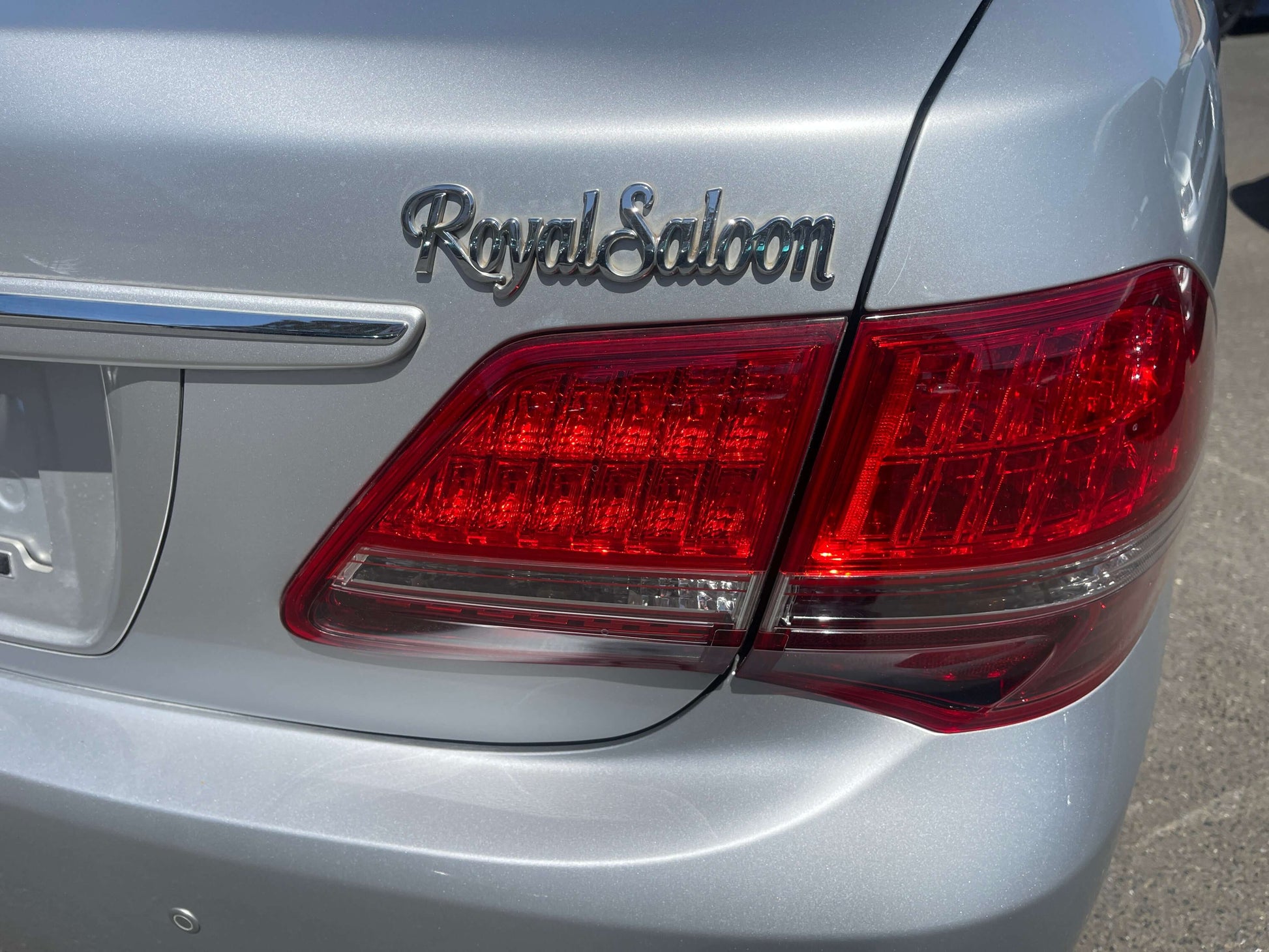 Close-up of the rear emblem and taillight of a 2008 Toyota Crown V6 3.0L Royal Saloon Luxury Sedan.