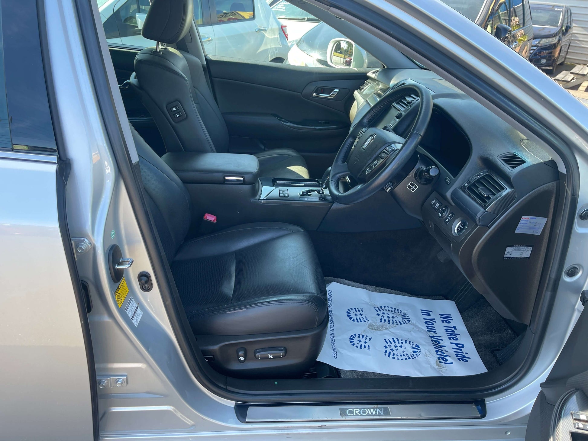 Interior view of the 2009 Toyota Crown V6 3.5L Hybrid luxury sedan showcasing black leather seats.