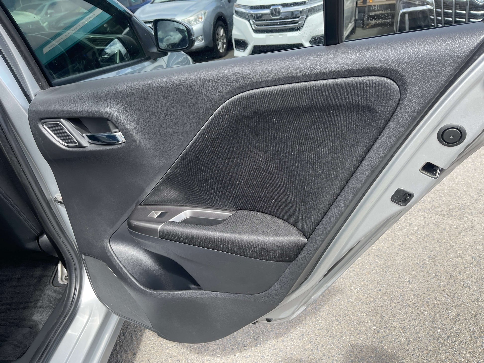 Interior view of 2015 Honda Grace 1.5 Hybrid driver door, showcasing sleek design and fabric accents.